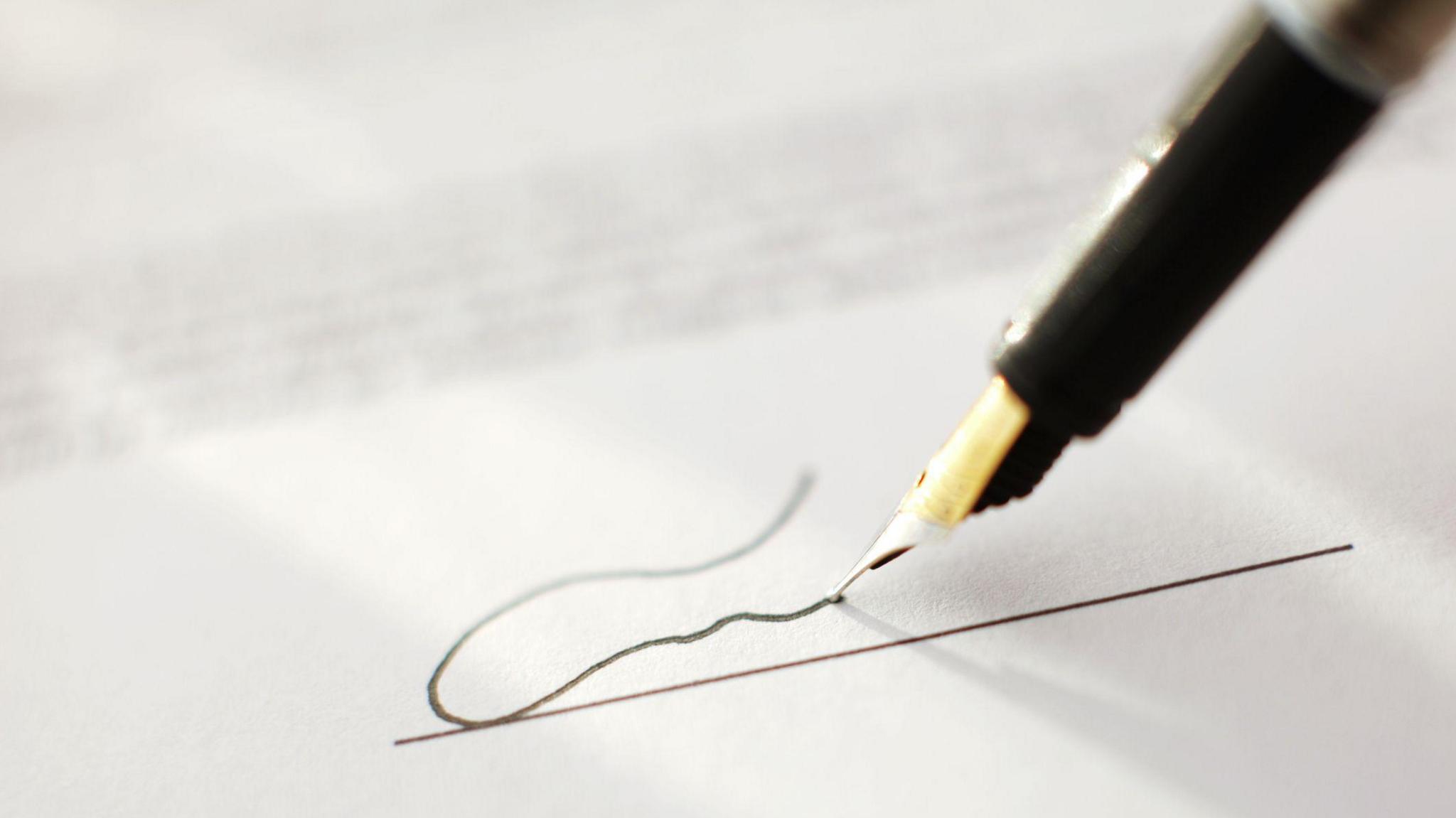 Close up of a fountain pen scribbling on a piece of paper 