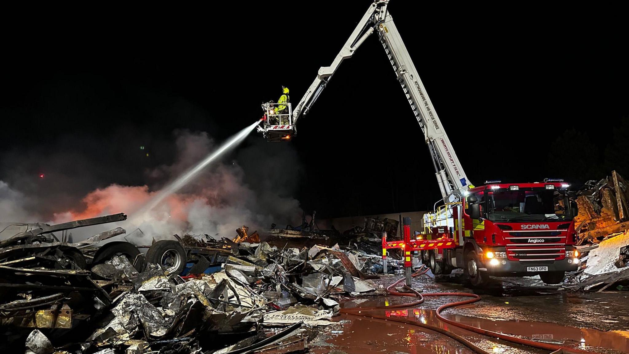 An aerial platform ladder used by the fire service at the scene of a fire on a recycling plant