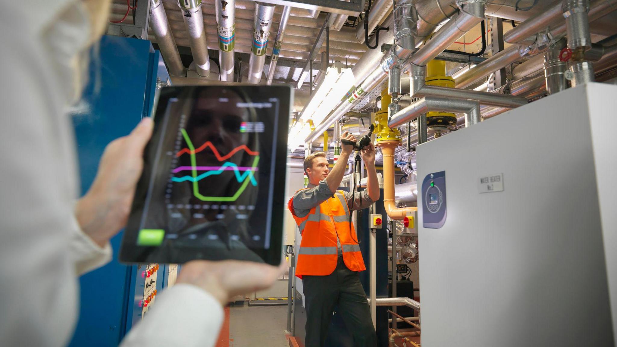 An energy efficiency survey being carried out at a business by a person holding an iPad.