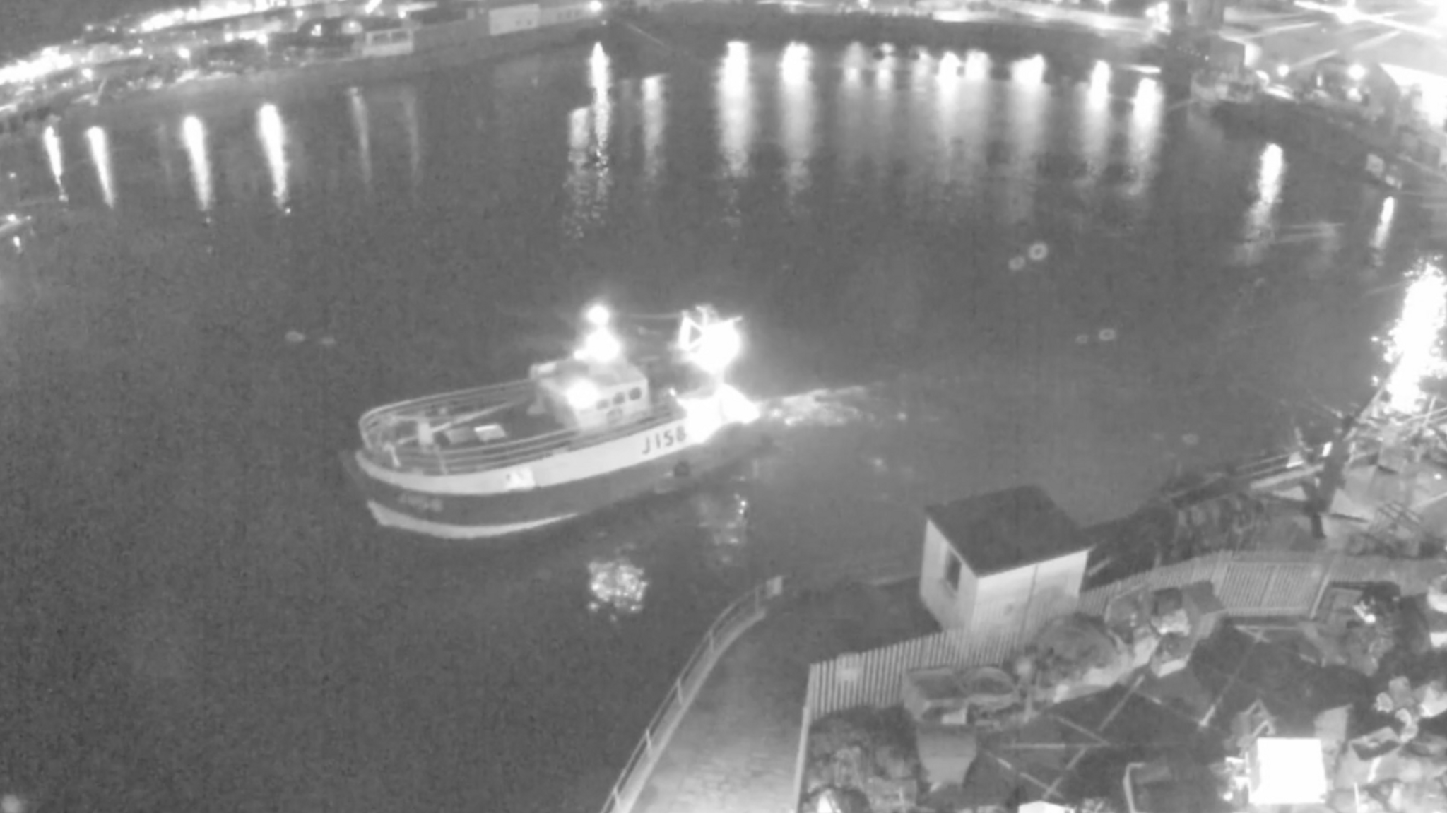 CCTV footage in black and white of a fishing trawler leaving the harbour.