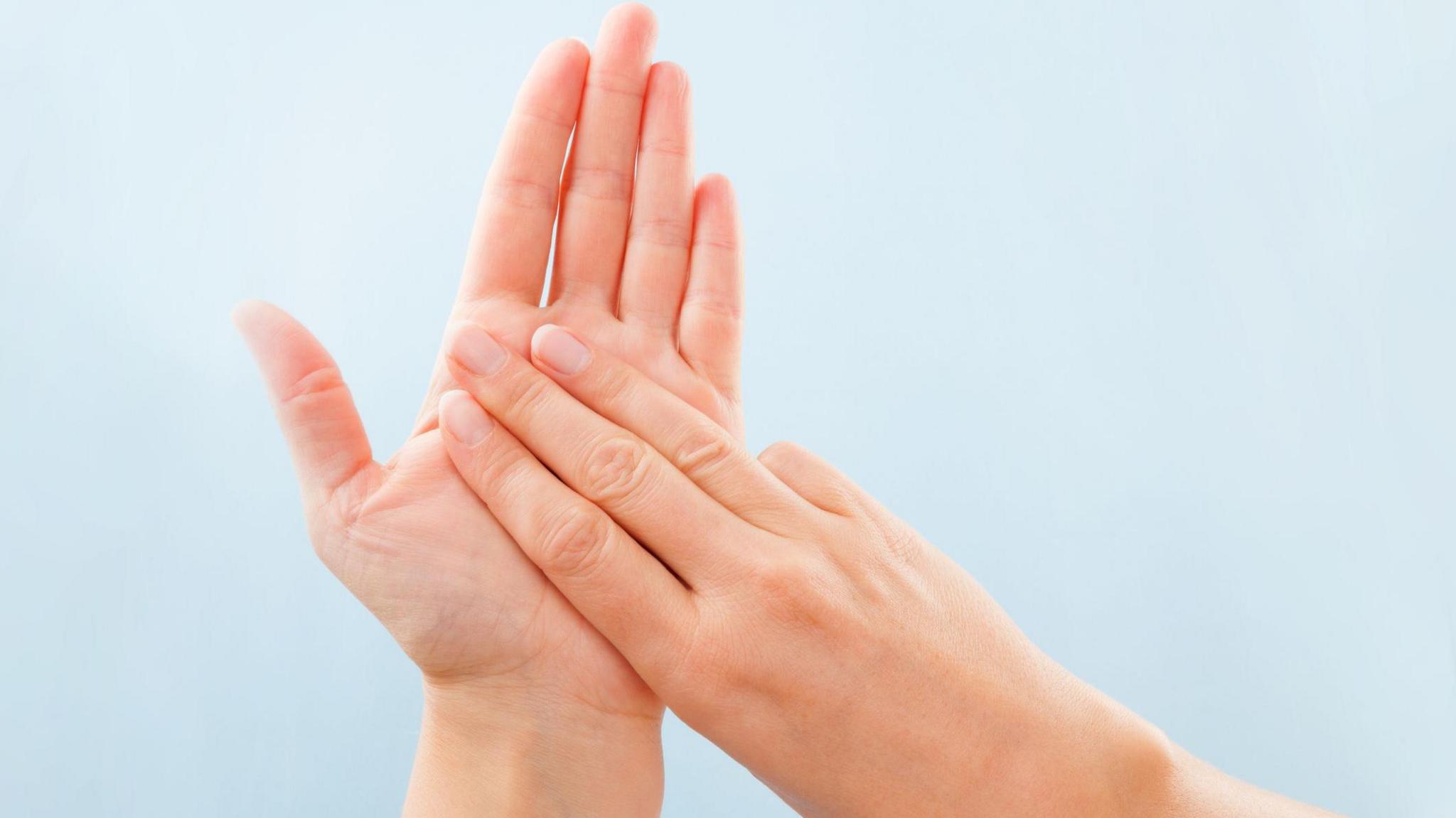 hands signing the letter 'M' in British Sign Language