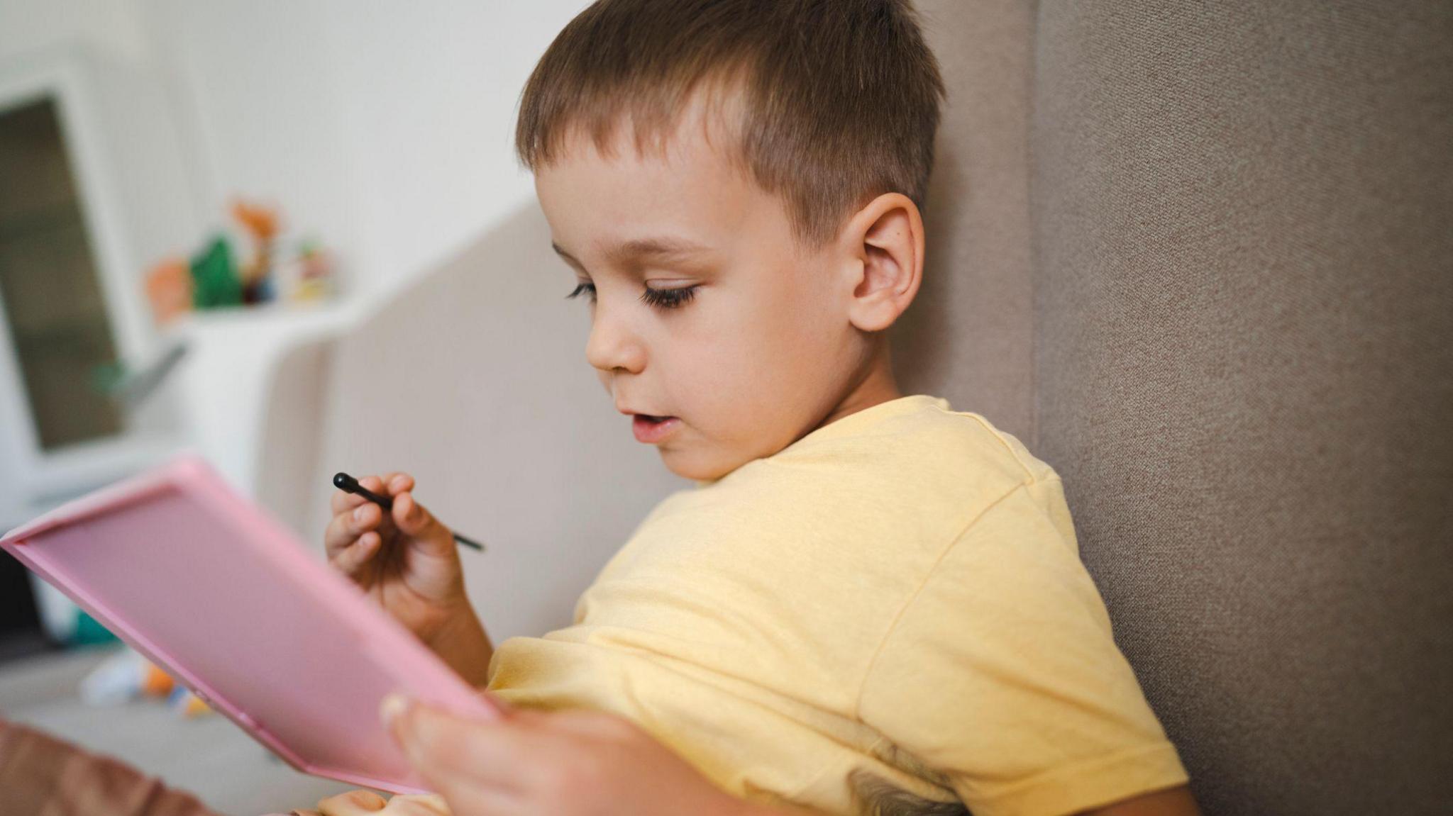 Young boy looking at notepad