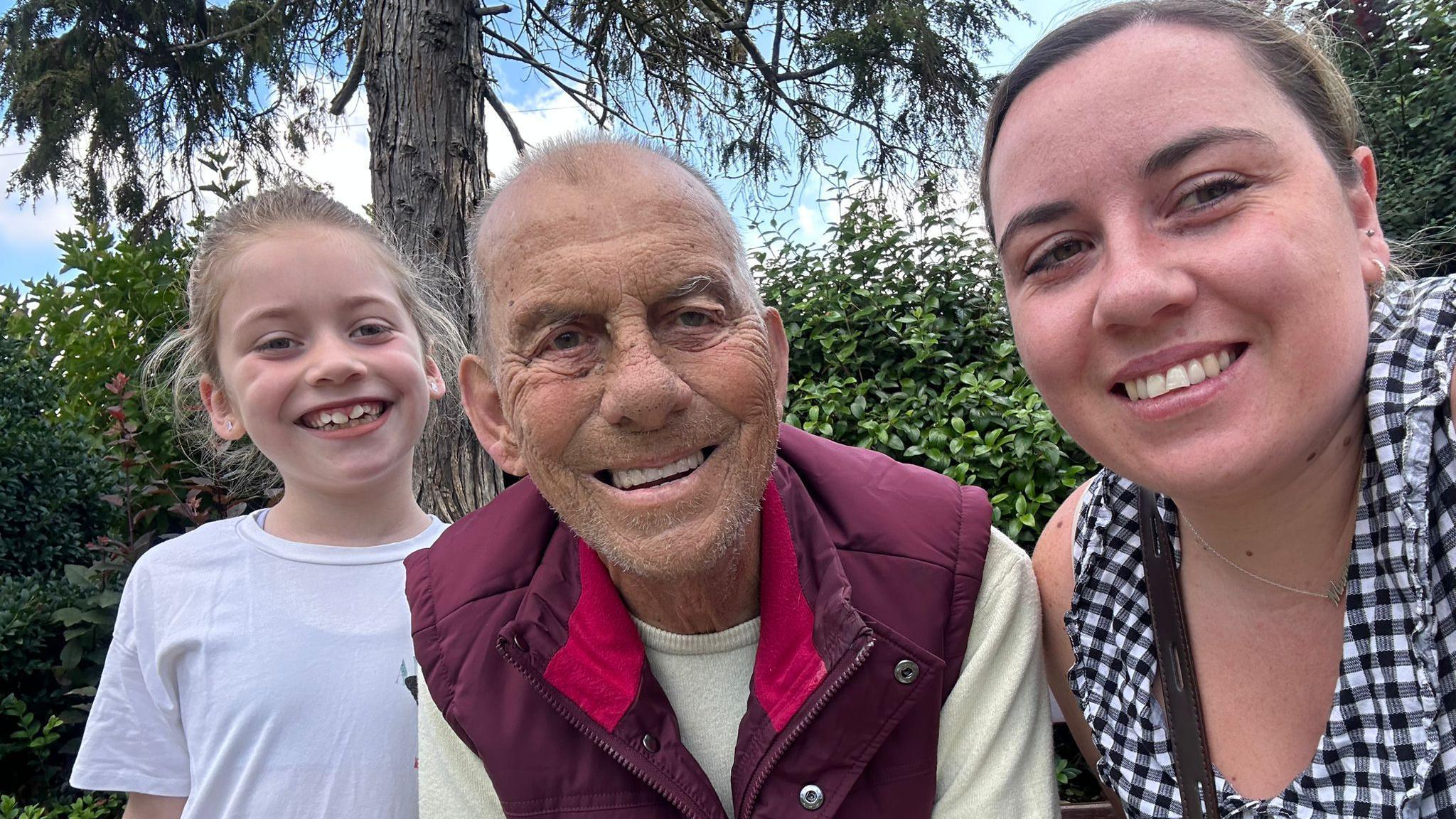 Darcy-Grace on the left wearing a white t-shirt, with Dave in the middle wearing a light-green jumper with a burgundy-coloured gillet, and Abbie is on the left wearing a black and white checked top 