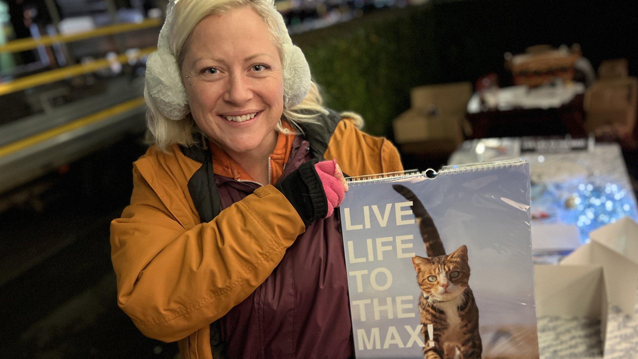 Georgie Dunt holding up a calendar for her cat Max