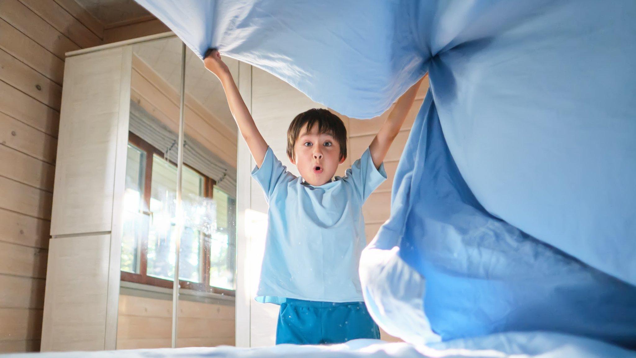 Boy making his bed