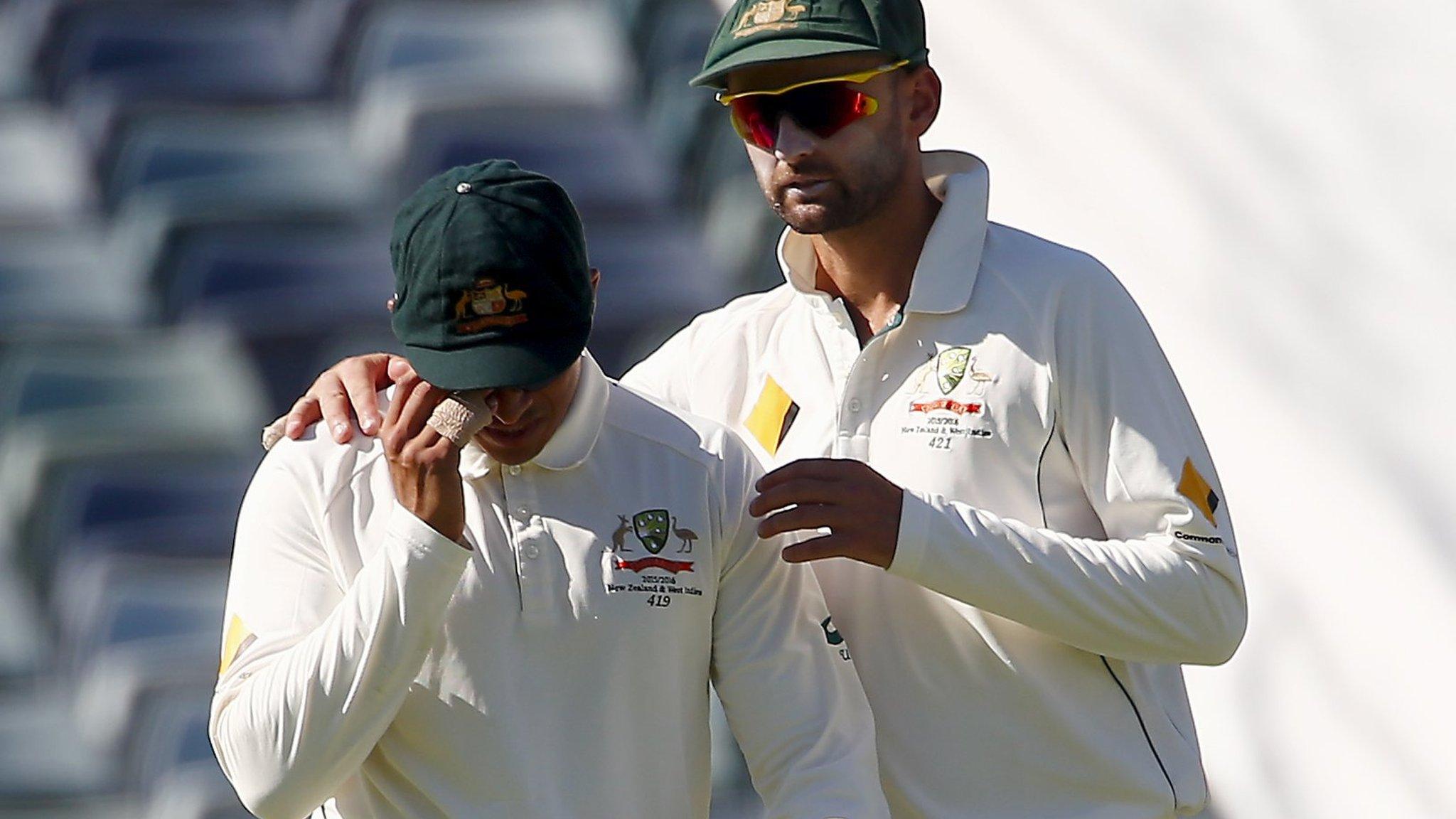 Usman Khawaja is consoled by team-mate Nathan Lyon (right)