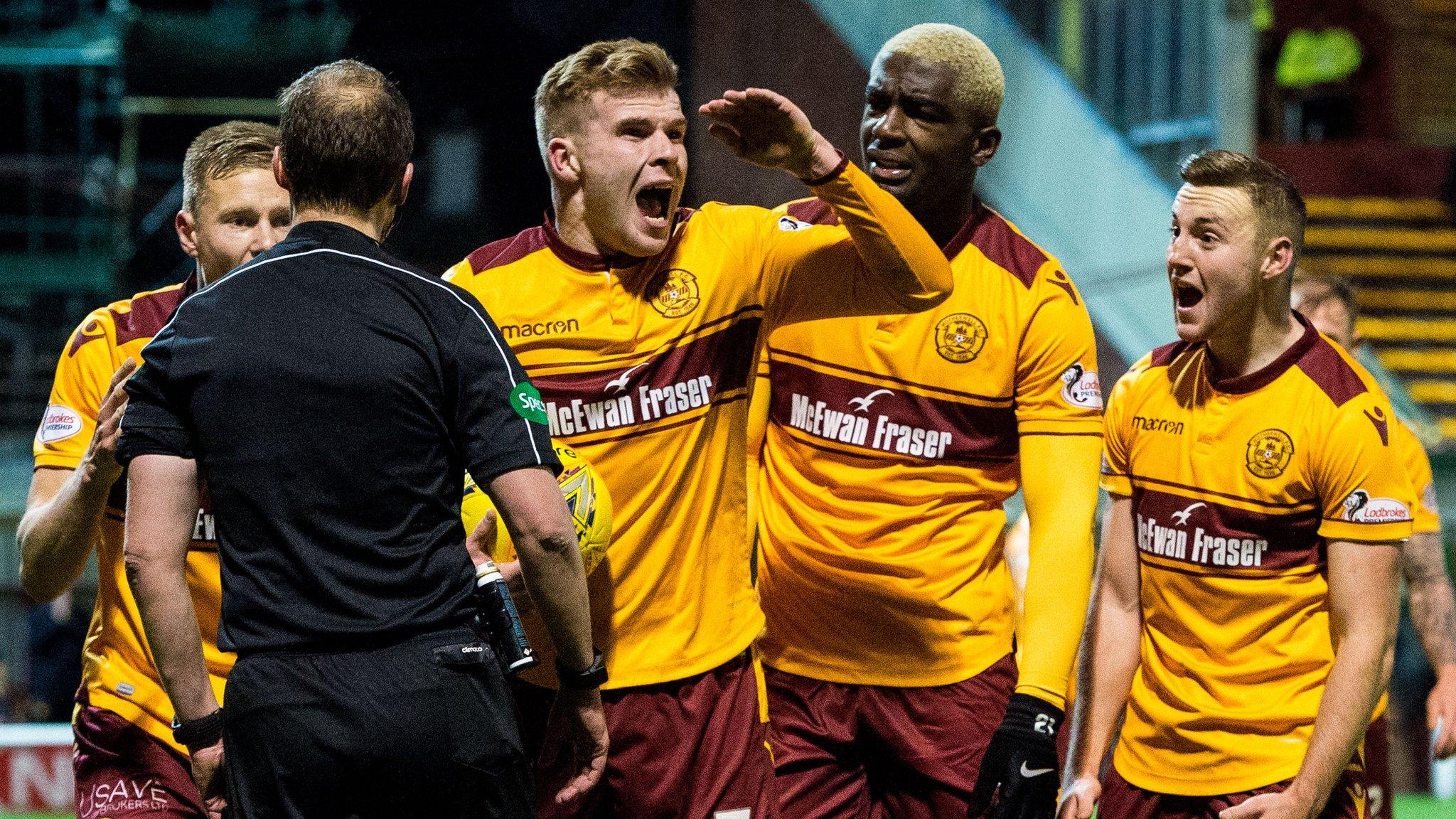 Motherwell players confront referee Willie Collum, after he awarded Celtic a controversial late penalty in the sides' draw