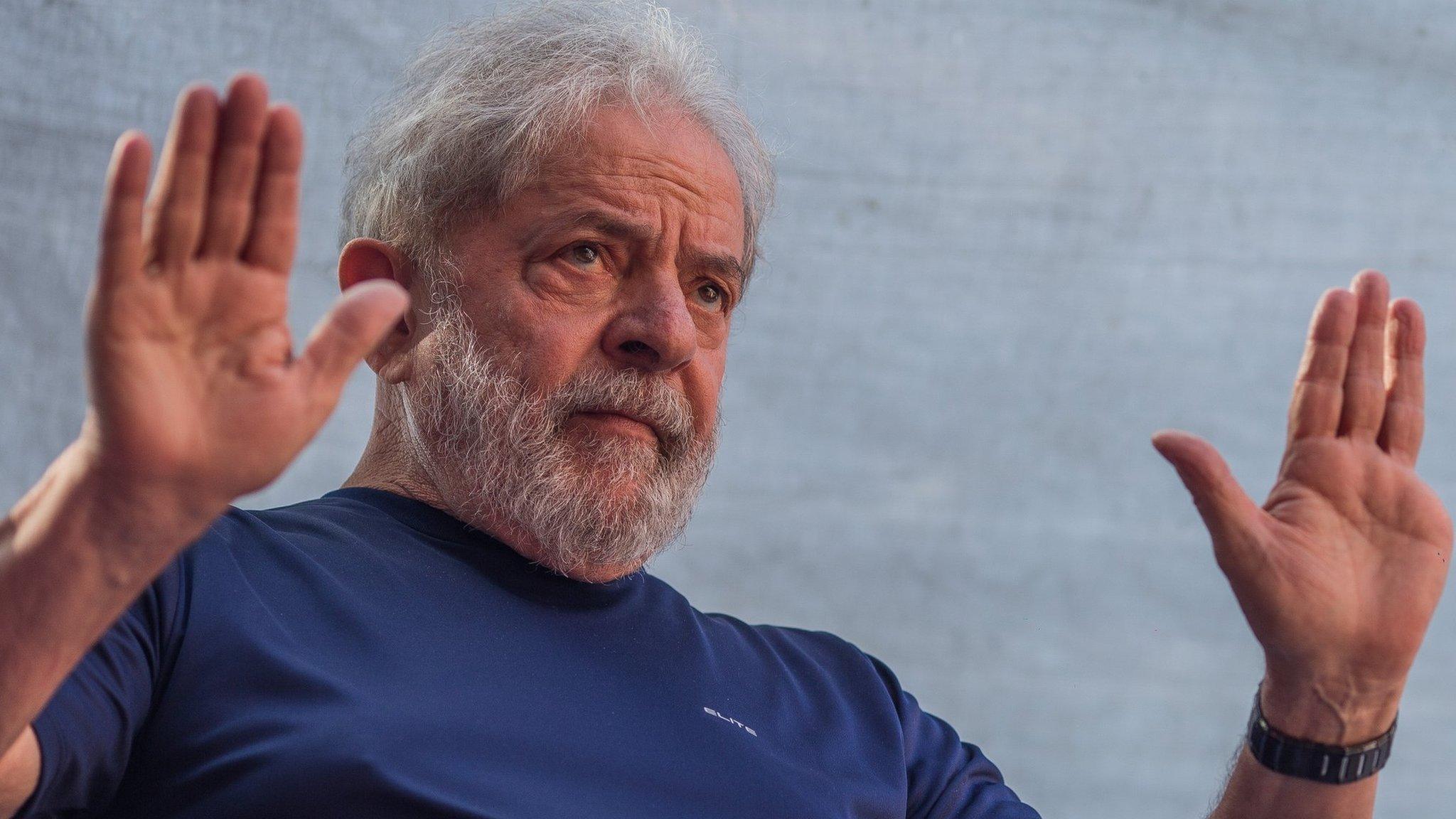 Lula holds up his hands as he addresses supporters