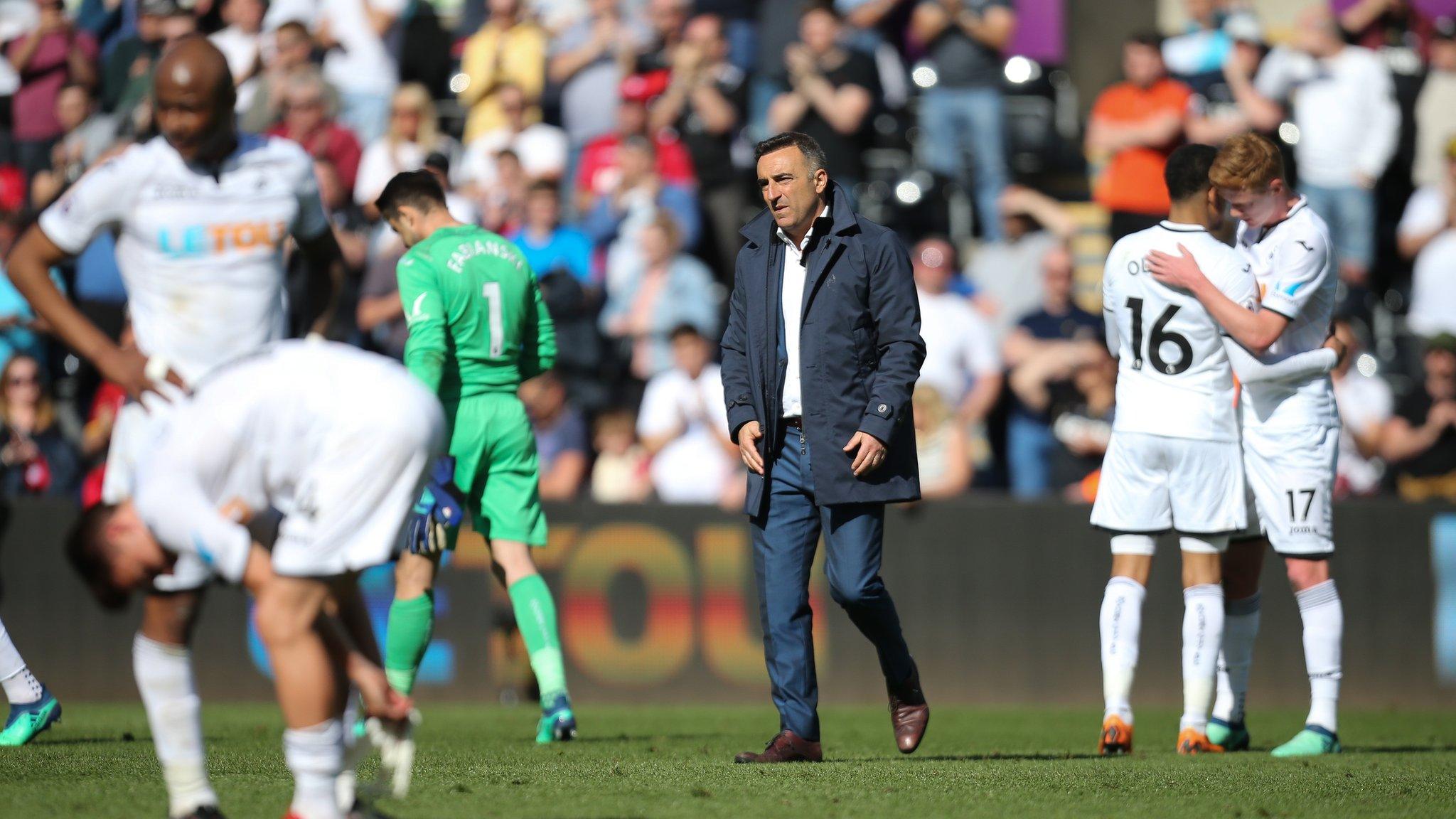 Swansea boss Carlos Carvalhal and his players are despondent after beign relegated