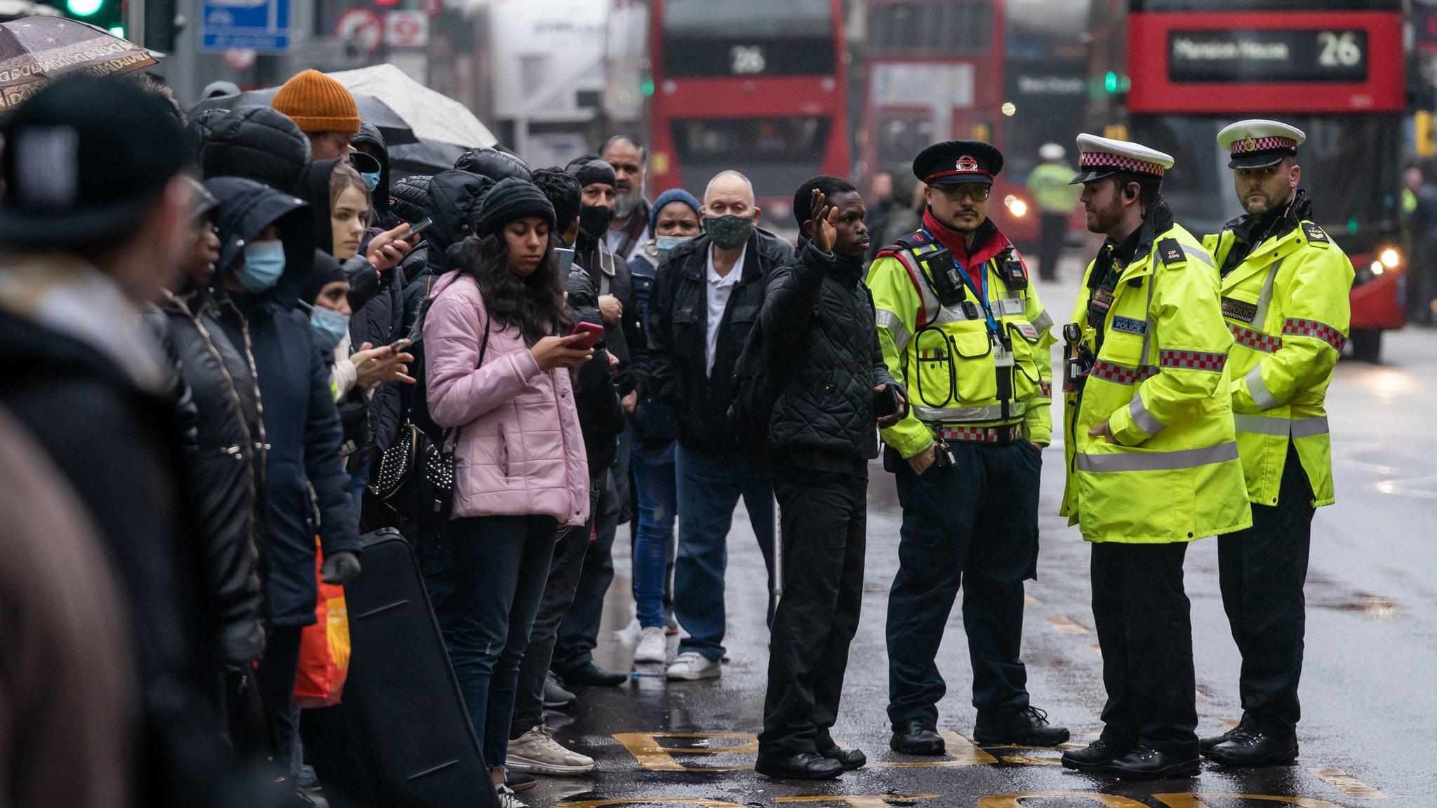 A man talks to police at Liverpool Street station in central London during a strike by members of the Rail, Maritime and Transport union (RMT)