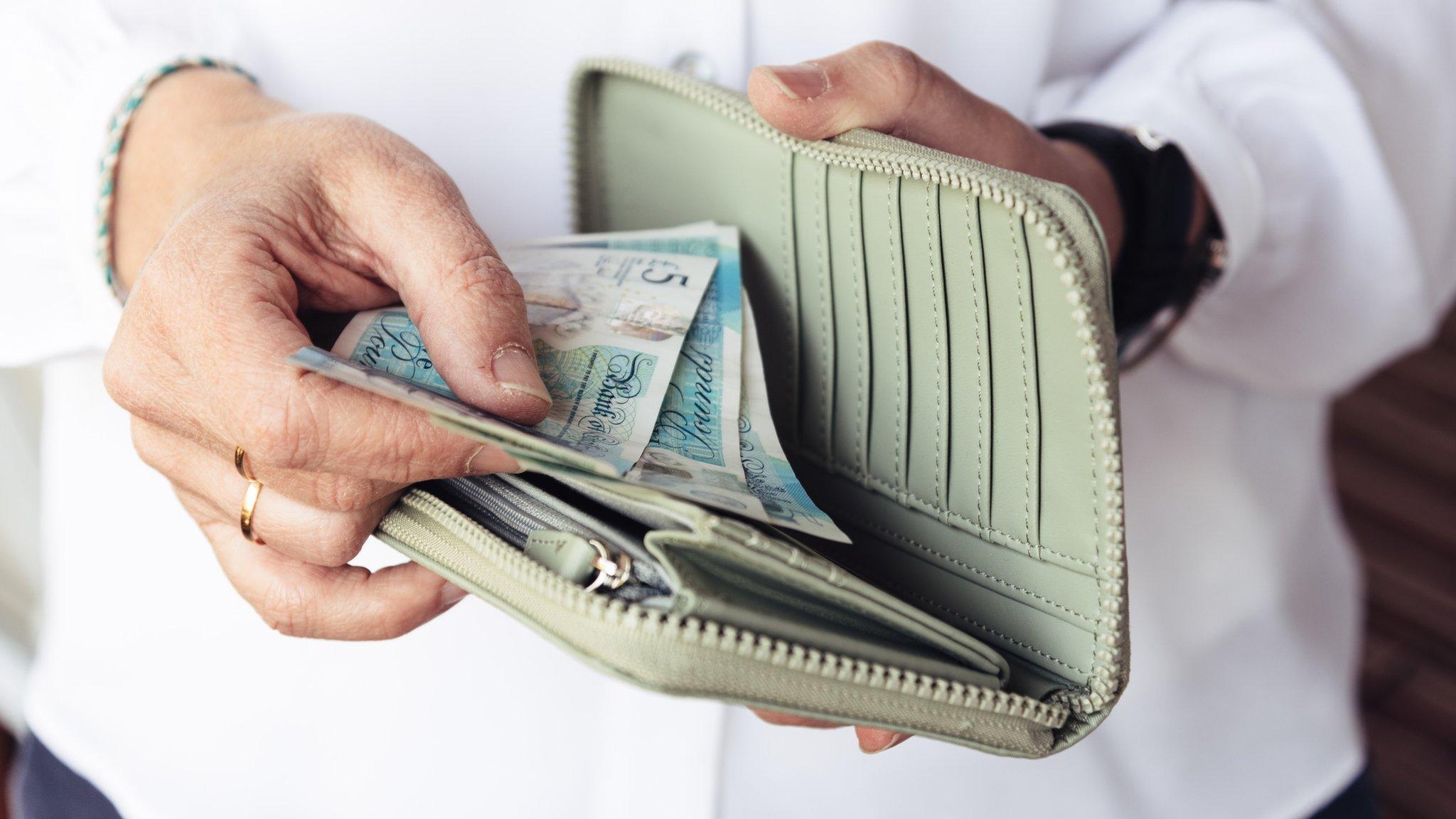 Woman looking at money in her purse