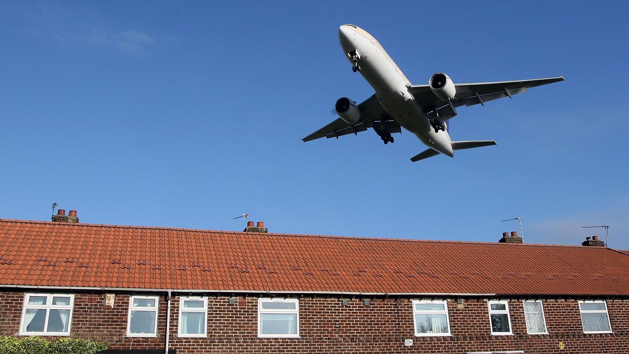 A plane flying over houses