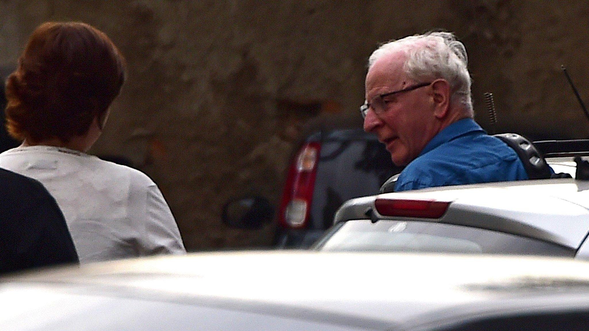 Pat Hickey (R) arrives at a police station in Rio de Janeiro, Brazil, 18 August