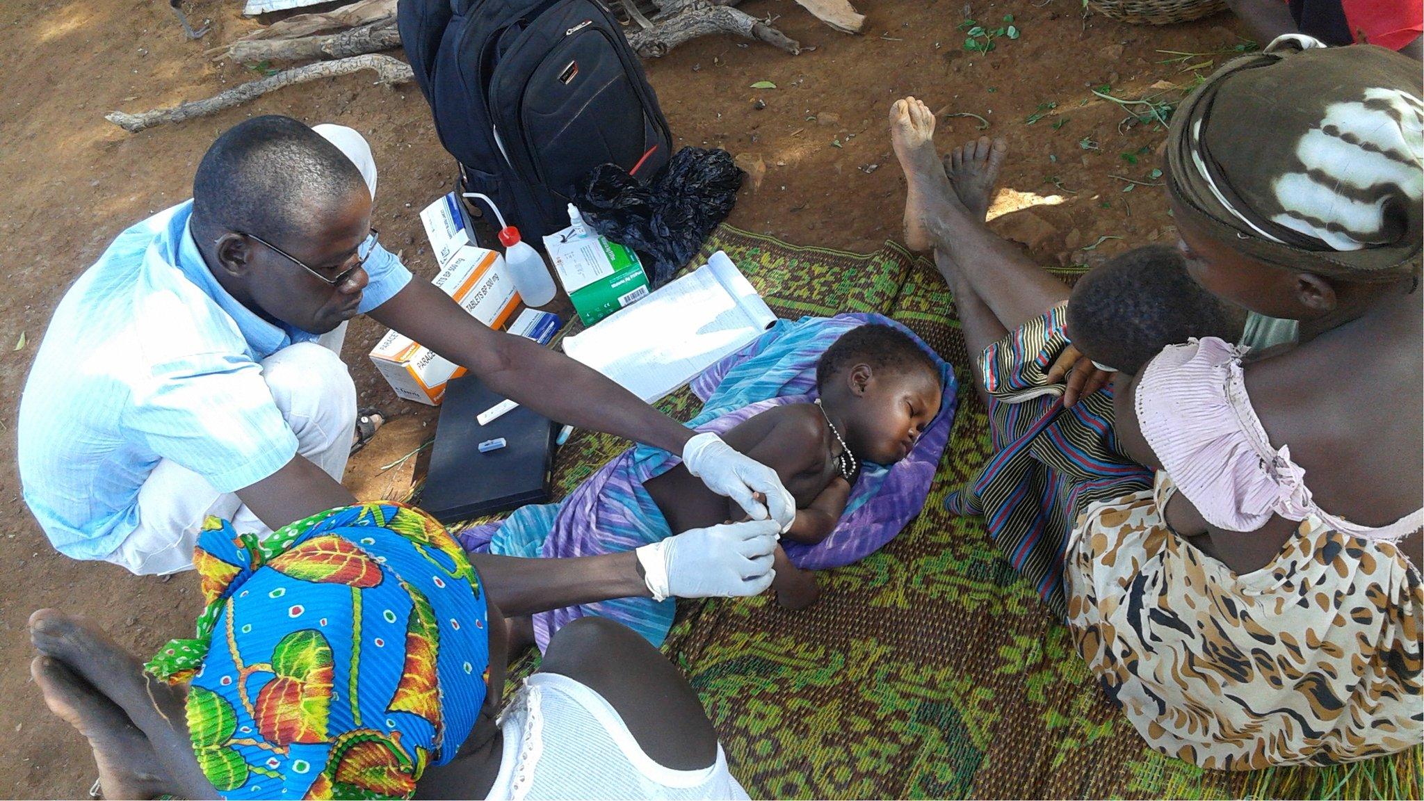 Nurses diagnosing malaria fevers in children in Burkina