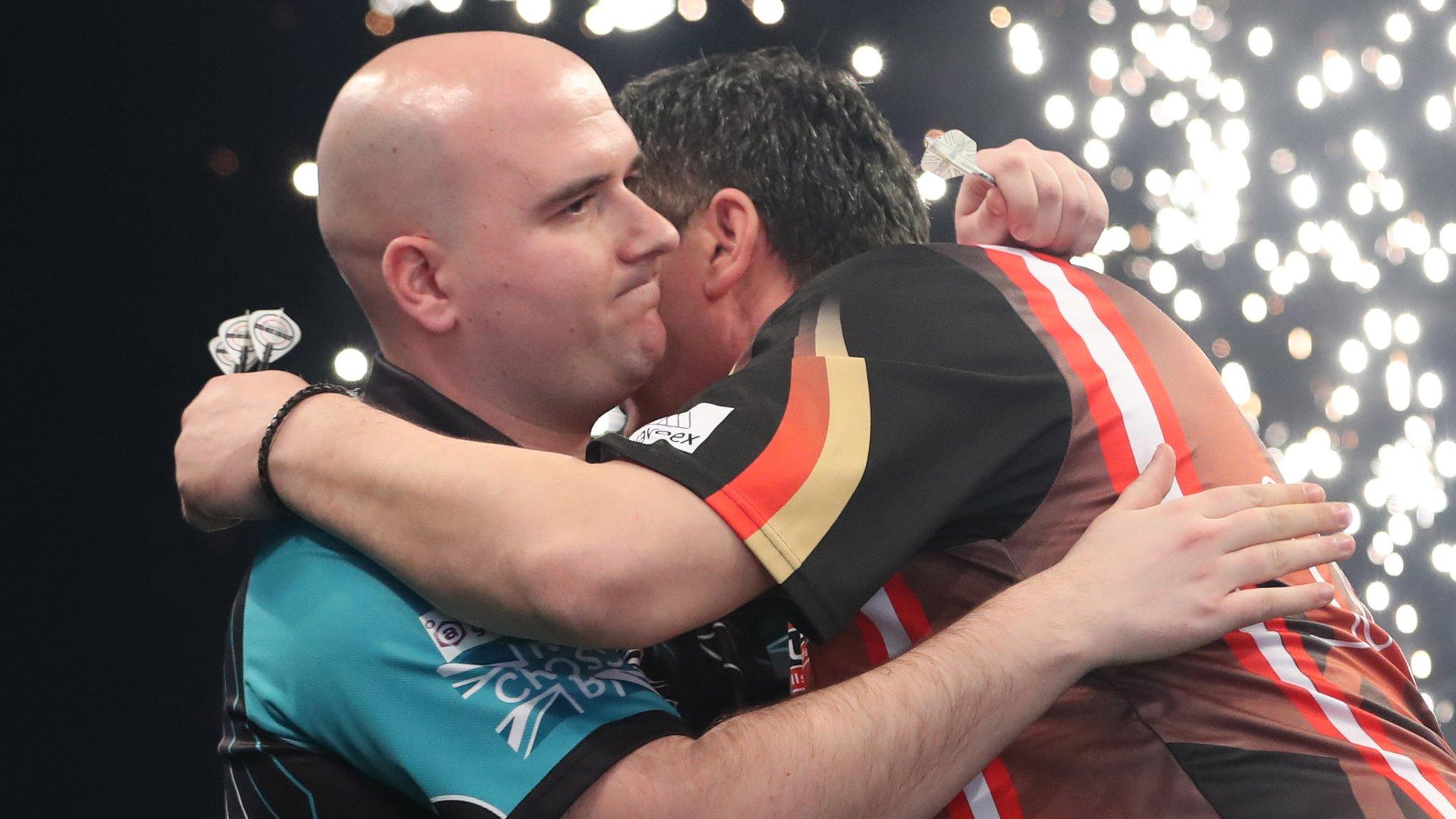 Rob Cross and Mensur Suljovic embrace