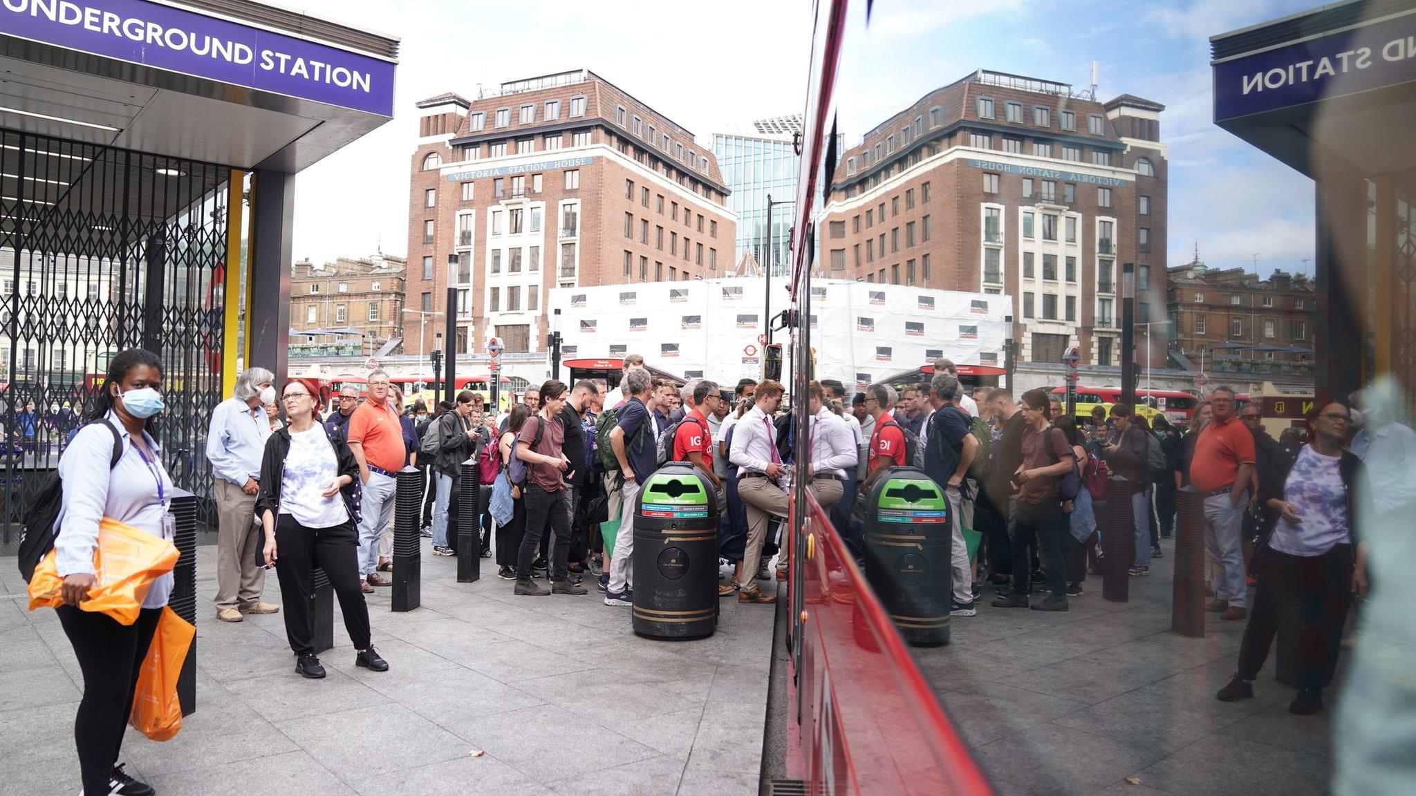 People waiting for a bus outside London's Victoria Station.