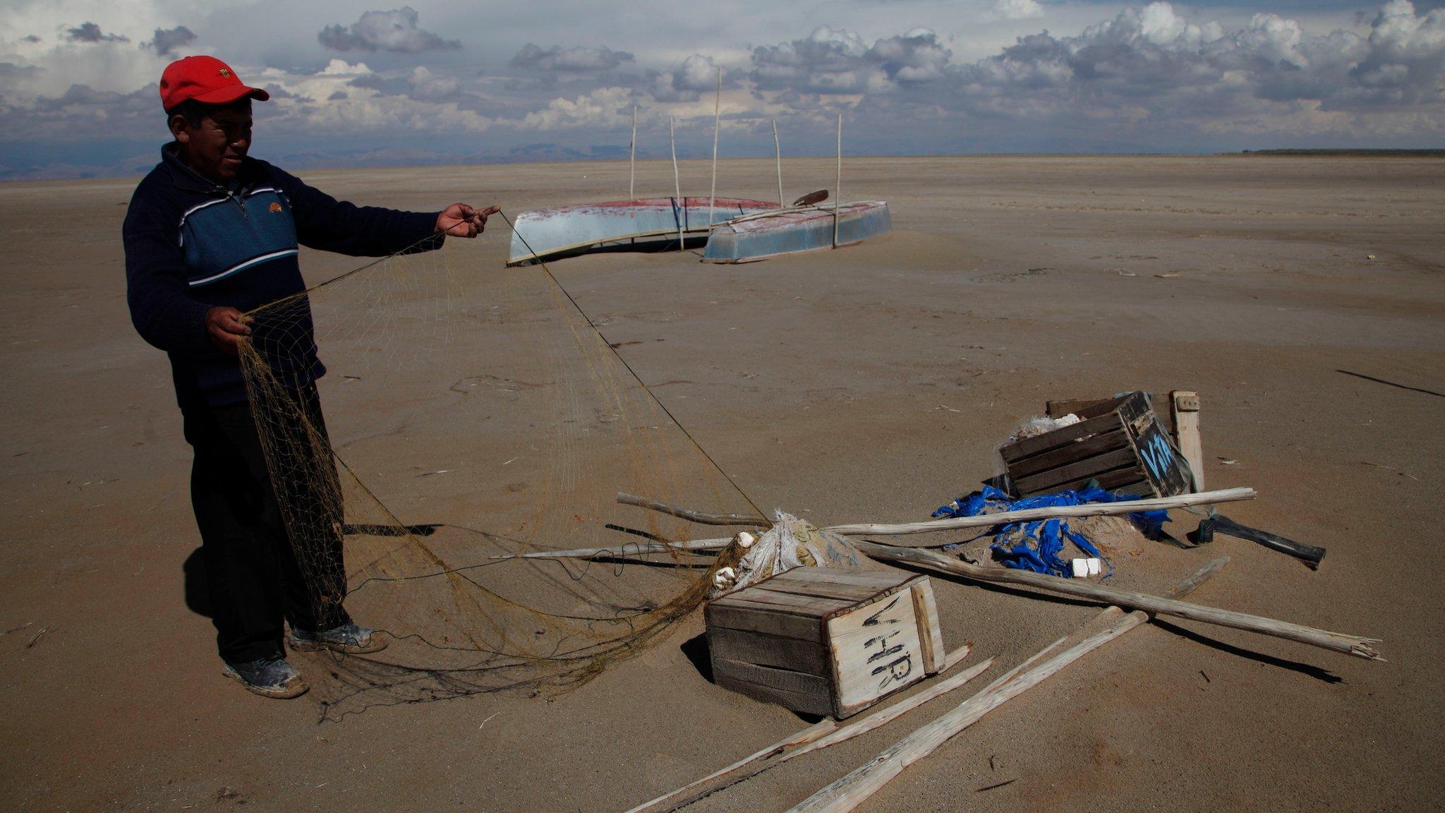 Fisherman in dried out lake