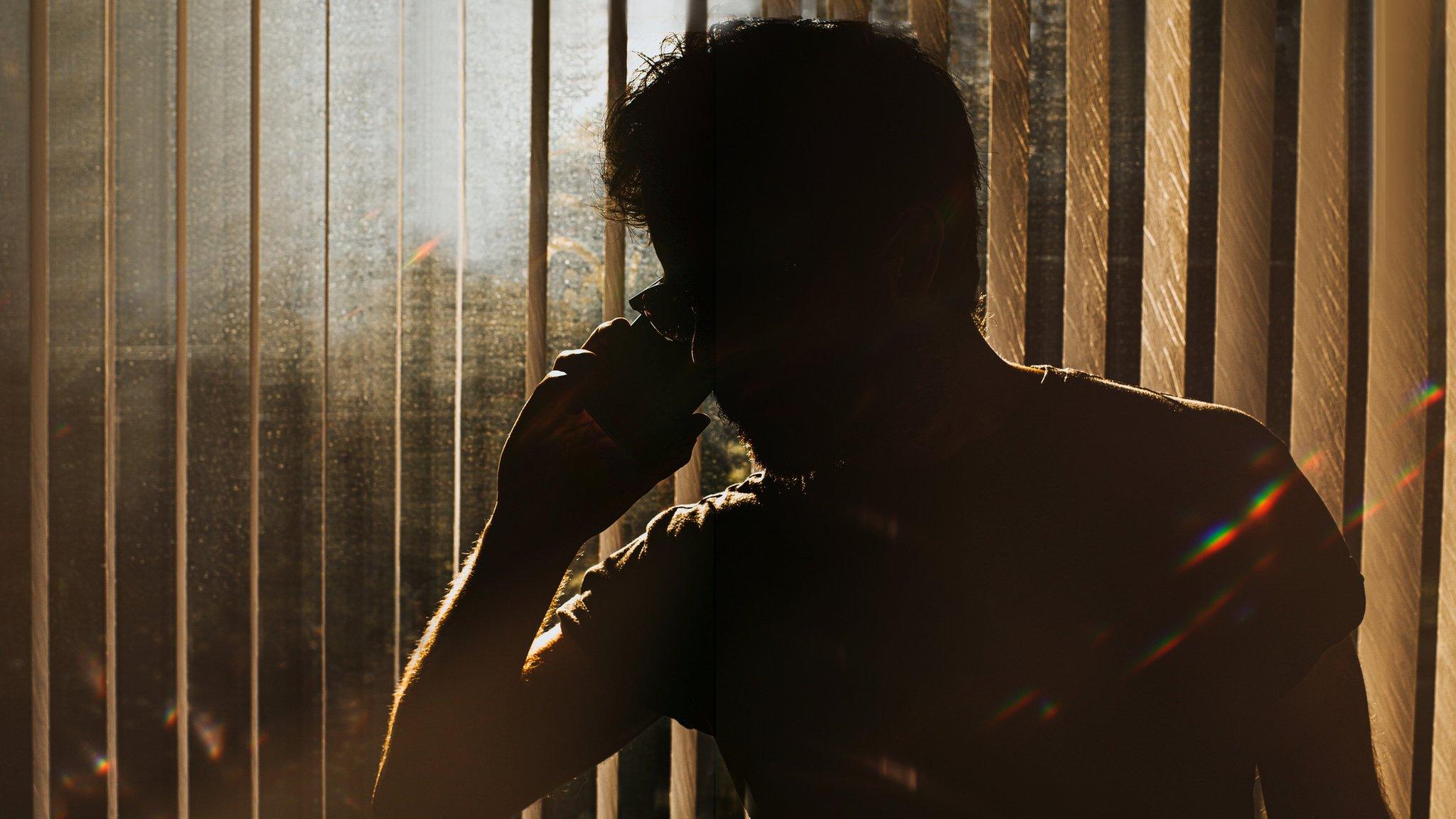 A man in silhouette on the phone