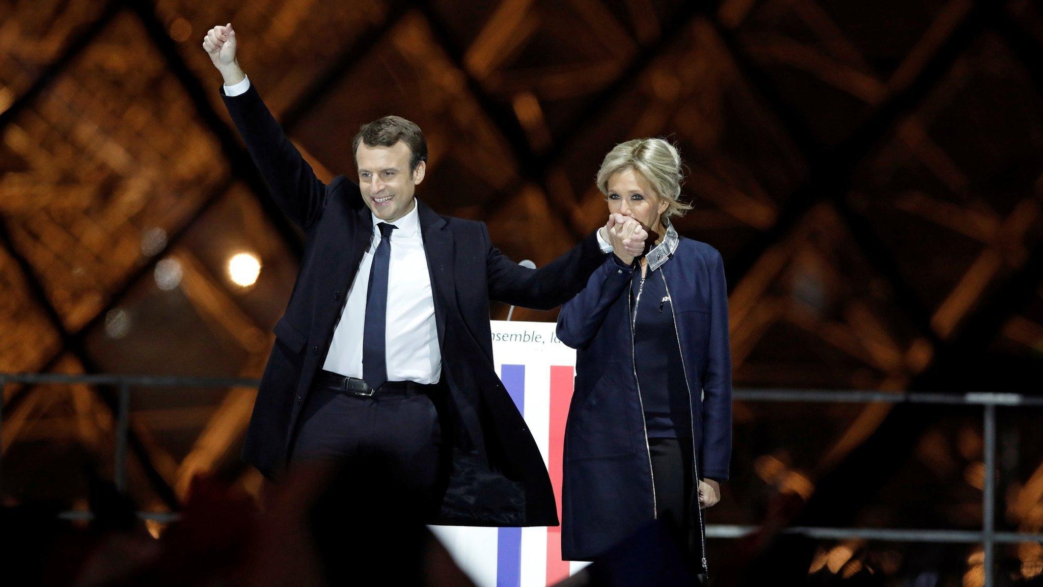 French President elect Emmanuel Macron and his wife Brigitte Trogneux celebrate on the stage at his victory rally near the Louvre in Paris