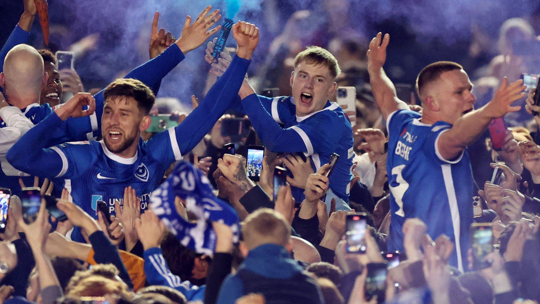 Portsmouth celebrate winning promotion with fans on the pitch