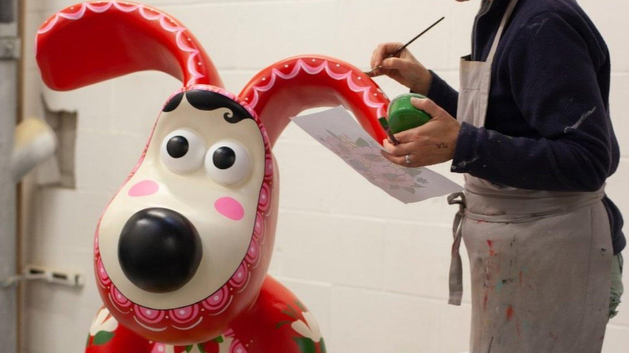 Artist painting a sculpture