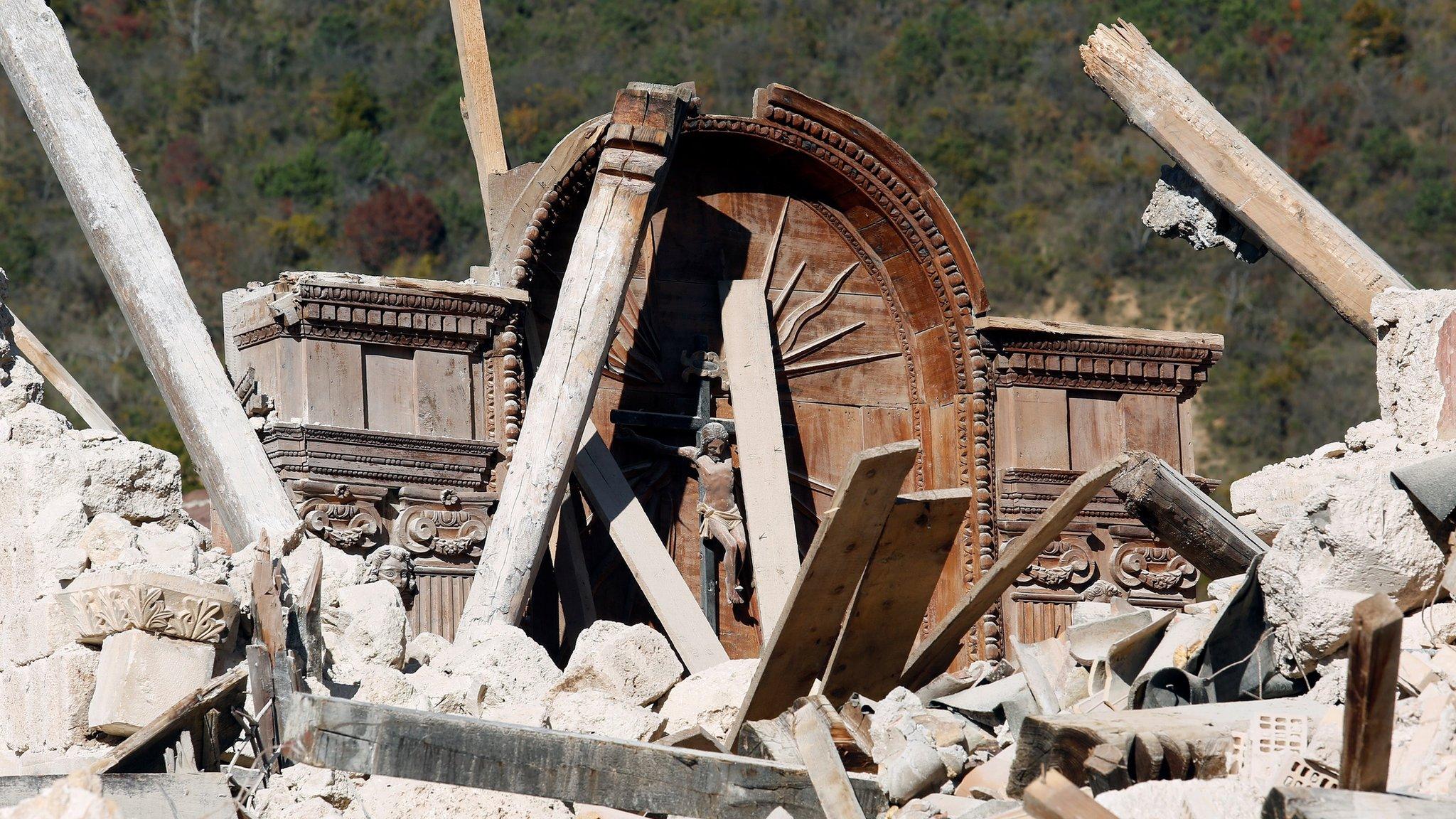 A crucifix is seen in the collapsed San Salvatore church in the village of Campi near Norcia, following an earthquake in central Italy (31 October 2016)