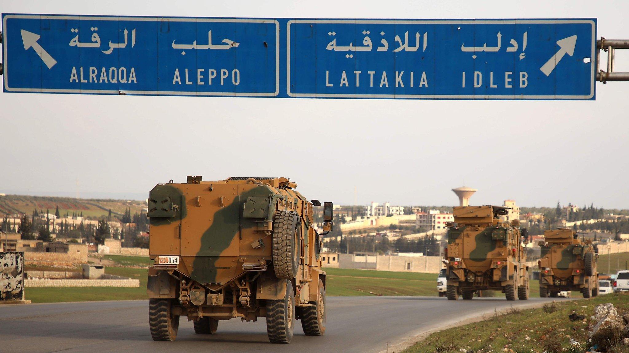 Turkish military vehicles drive past the town of Atareb, Syria, as they head towards Idlib province (3 February 2020)