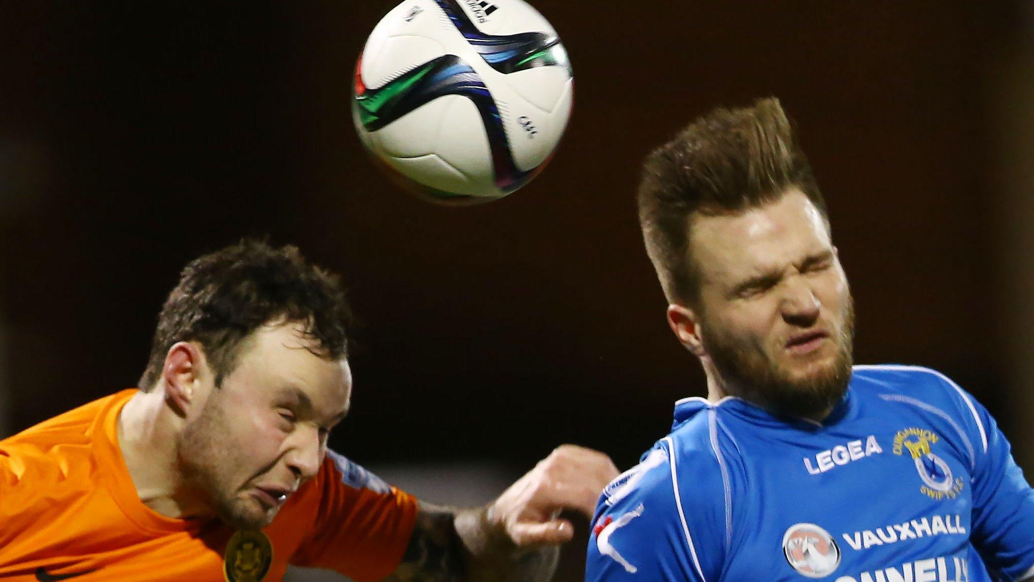 Dungannon Swifts Captain Ryan Harpur challenges Andrew Doyle of Carrick Rangers in the air