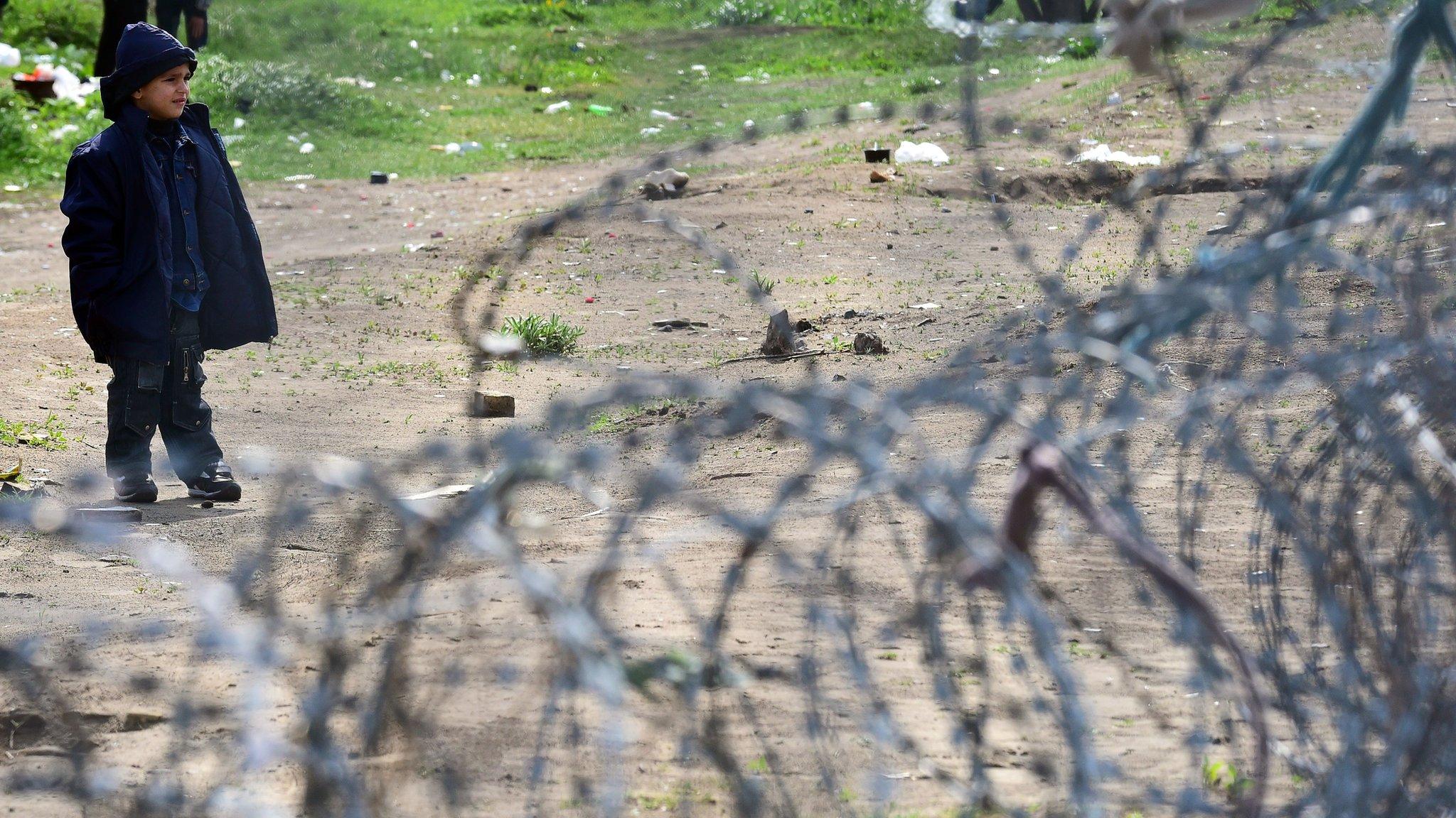 A young migrant boy waits in front of the Hungarian border fence at the Tompa border station transit zone on 6 April 2017 as the Hungarian Interior Minister Sandor Pinter (not pictured) presents the camp to the media