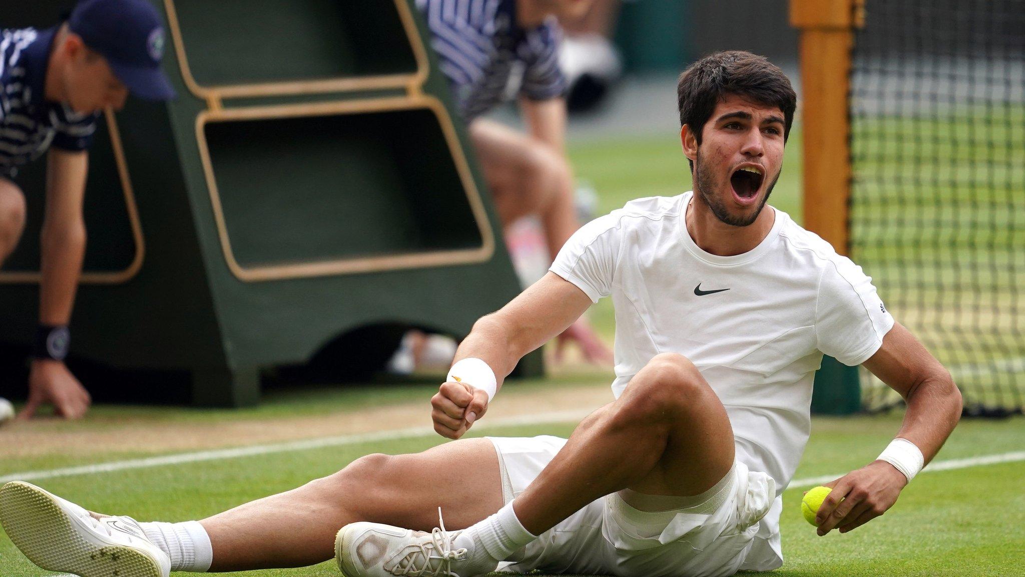 Carlos Alcaraz lies on Centre Court grass after beating Novak Djokovic in Wimbledon final