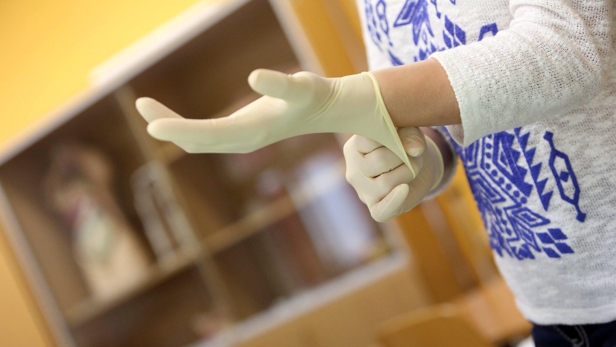 Student training in elderly care puts on rubber gloves in Berlin, Germany (14 May 2014)