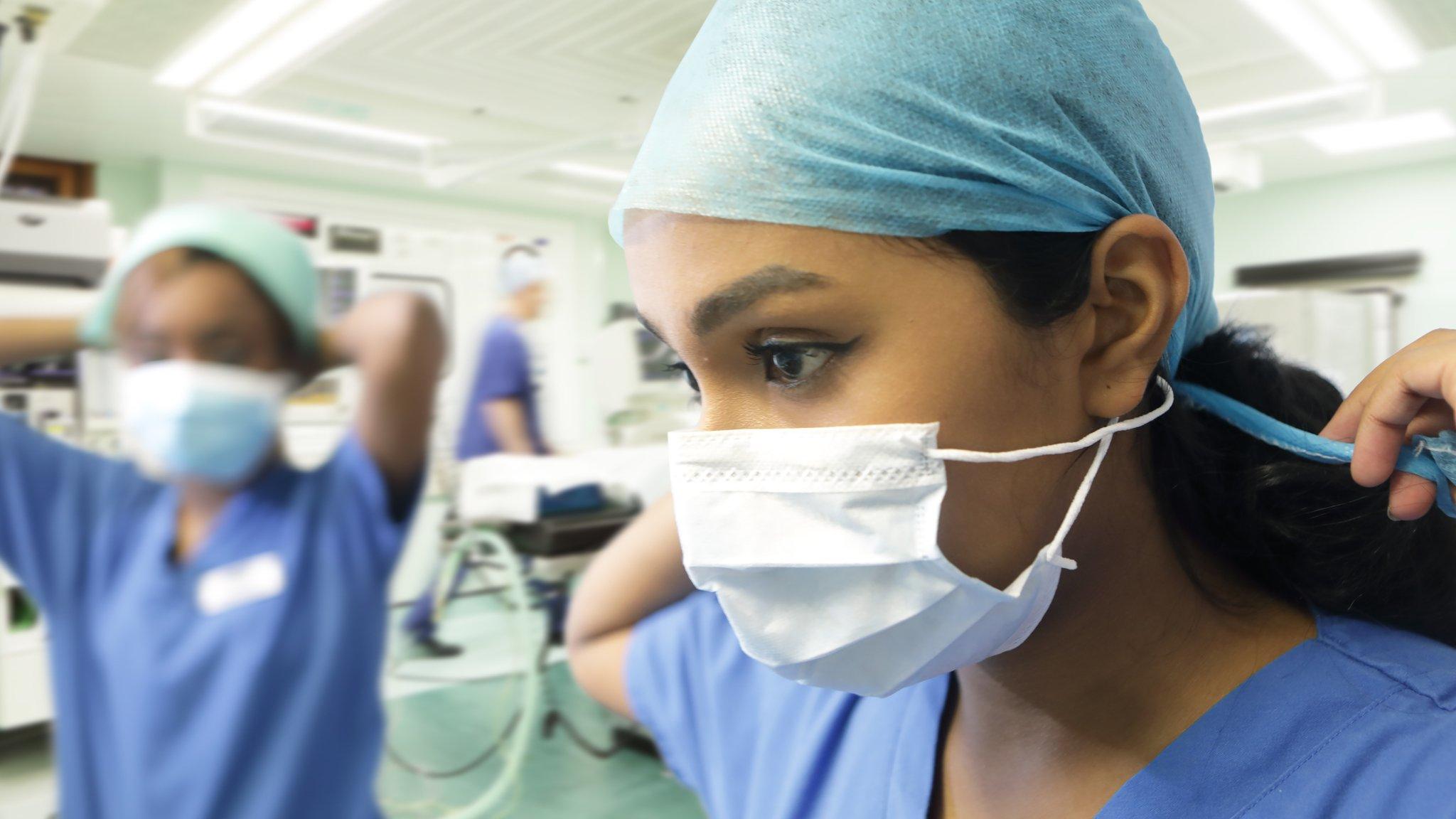 Hospital staff putting on PPE