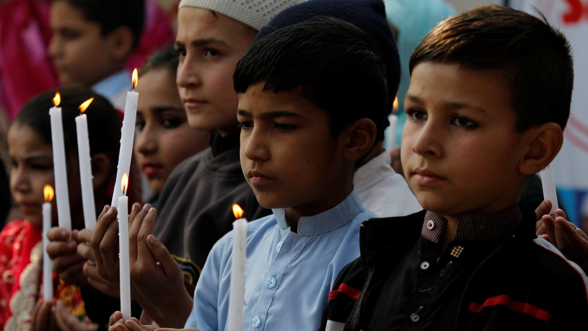 Pakistani school children light candles and pray to mark the second anniversary of terrorists attack on Army Public School attack in Peshawar, Pakistan, 16 December 2016