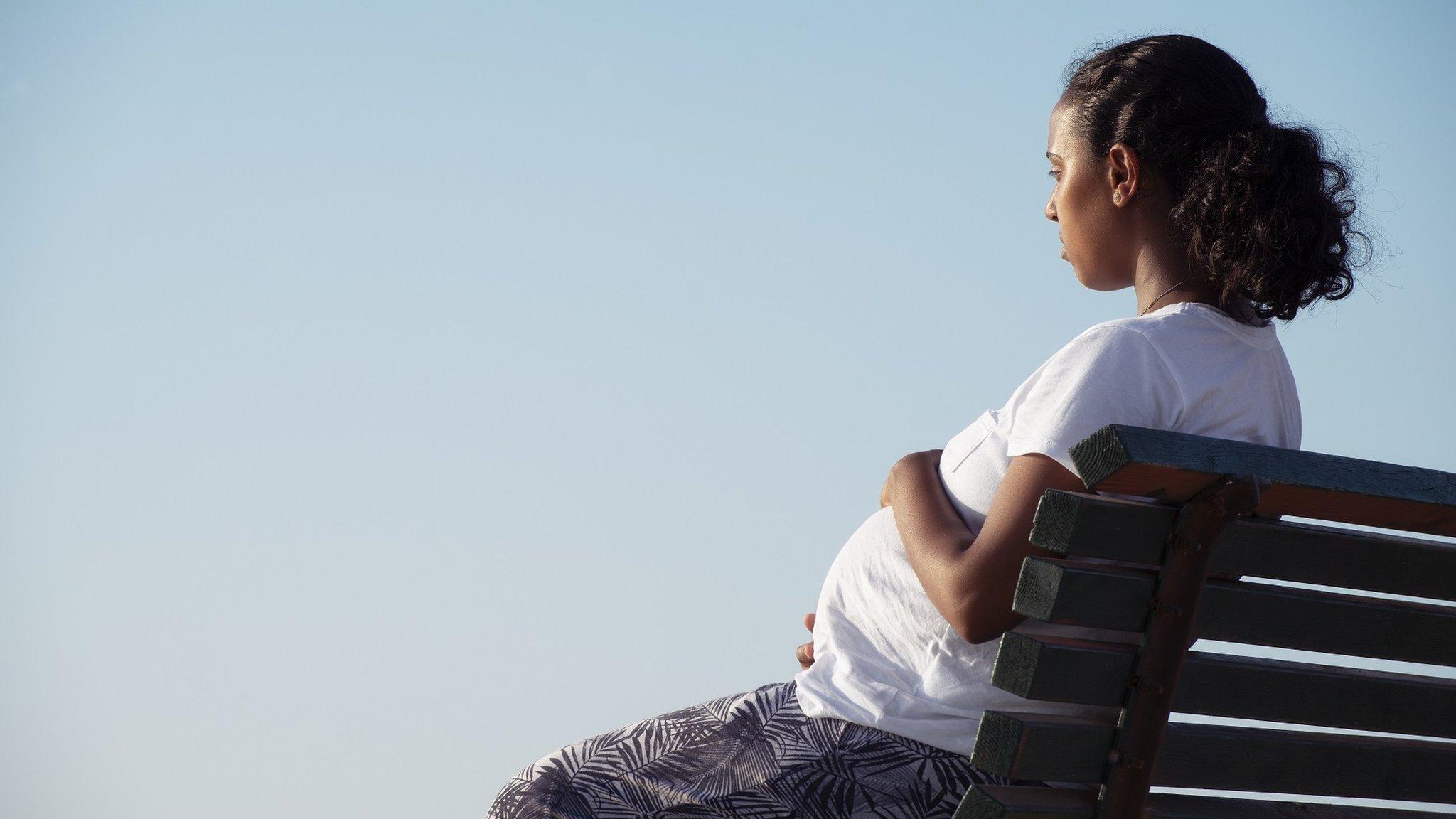 Pregnant woman sitting on a bench