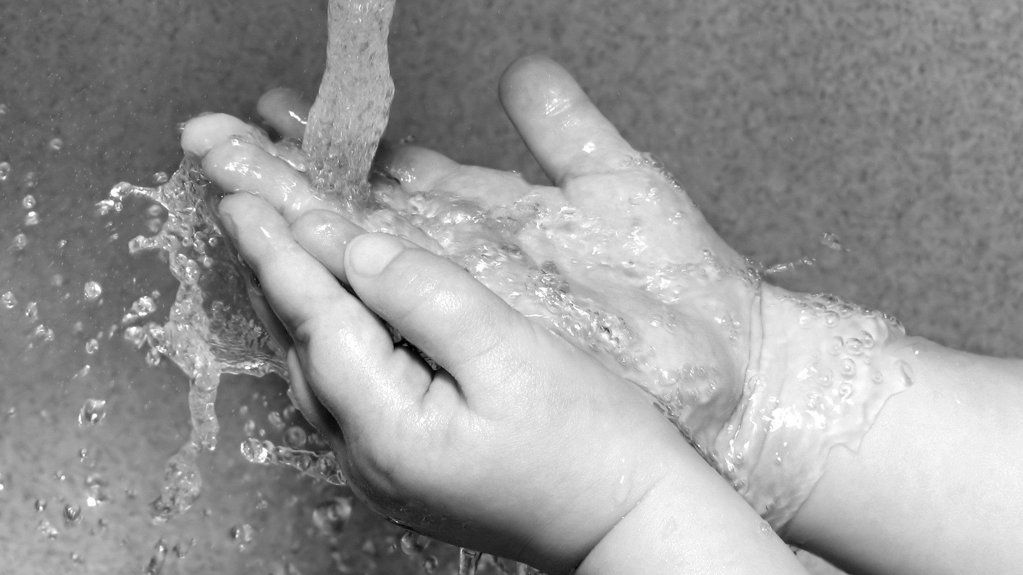 Hands being washed, in a black and white photograph