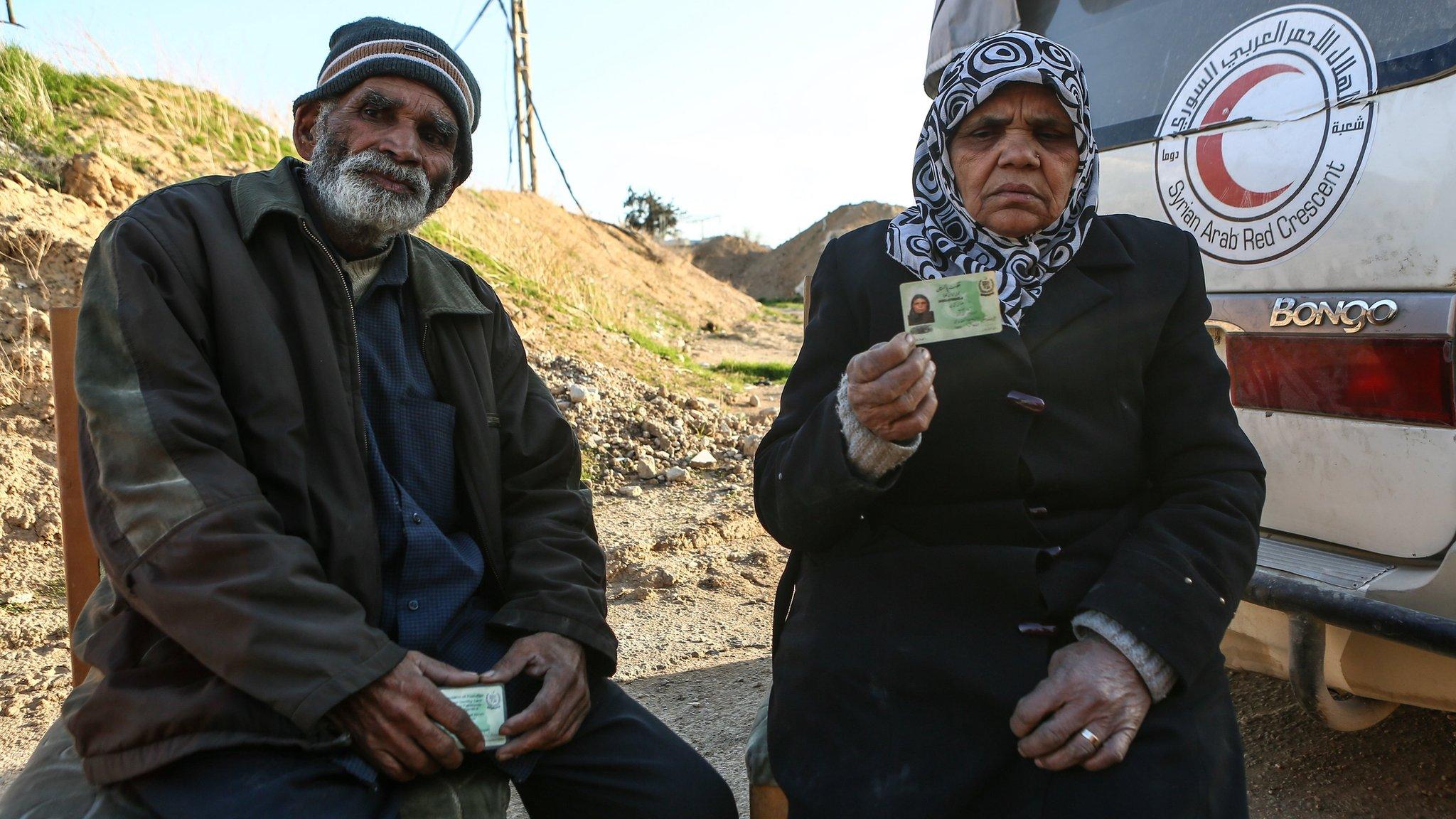 A Pakistani couple sit next to a Syrian Arab Red Crescent (SARC) ambulance as they prepare to leave the rebel-held Eastern Ghouta town of Douma, Syria (28 February 2018)