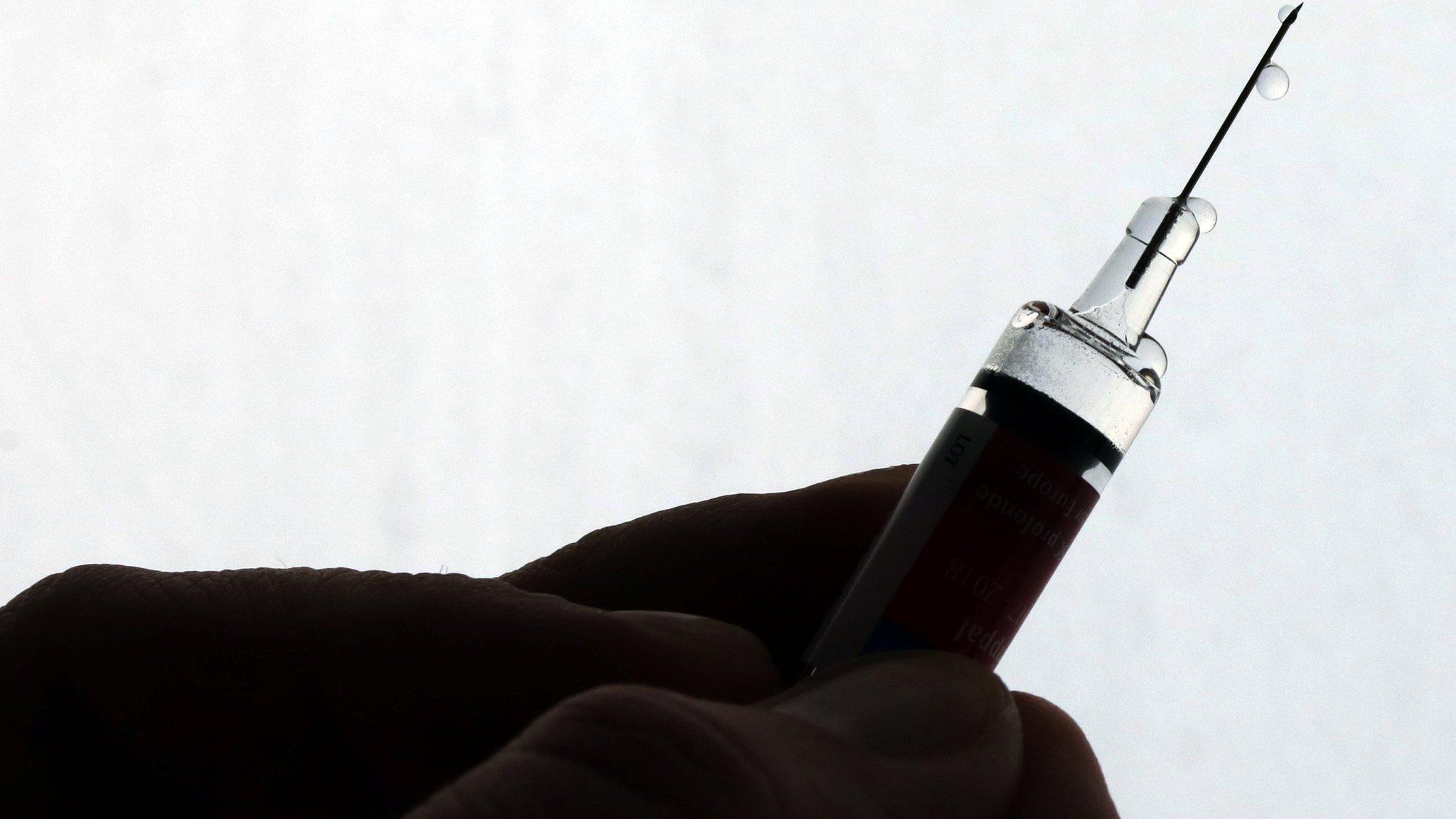 A doctor prepares a syringe