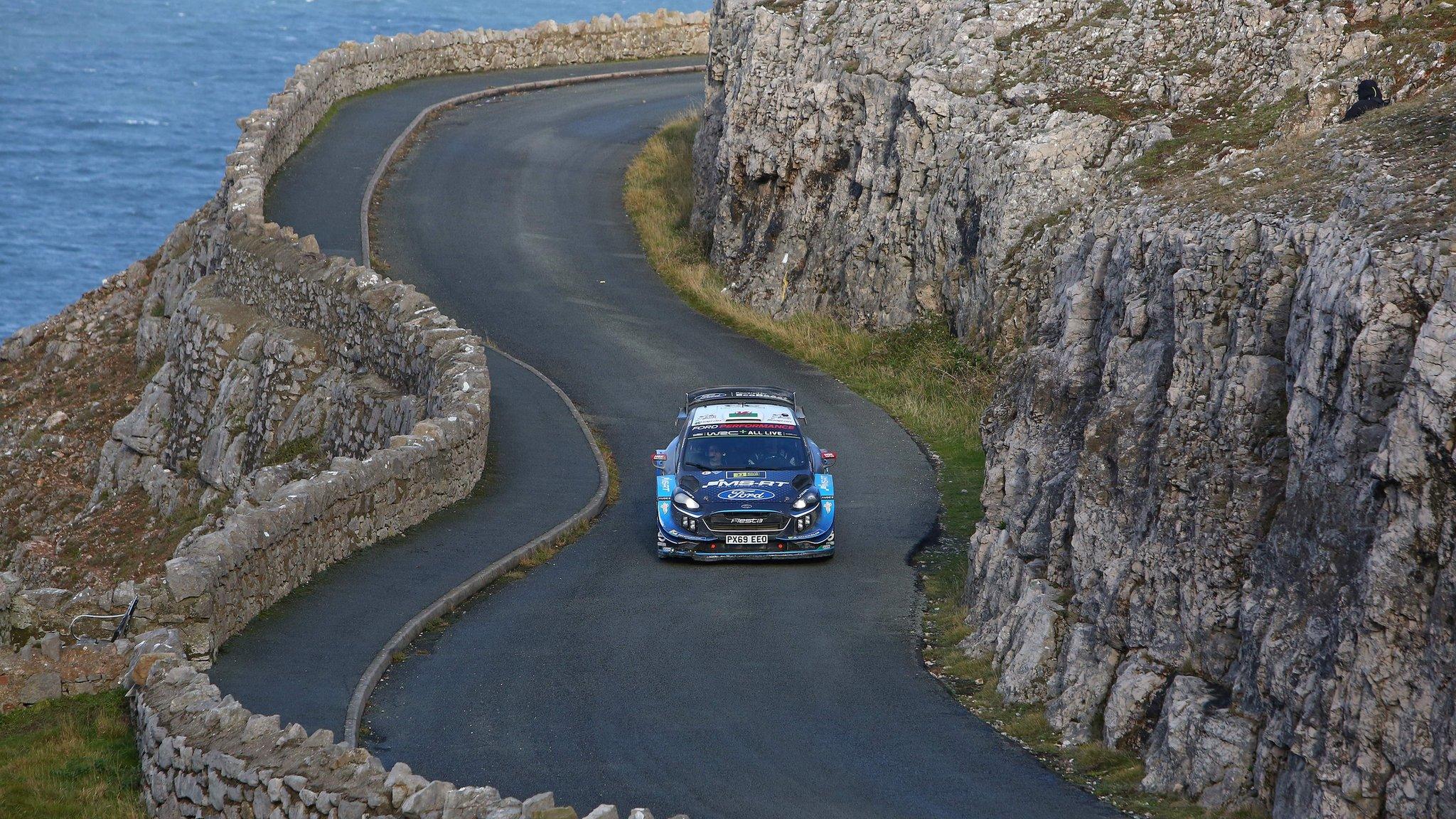 rally car driving along coast road