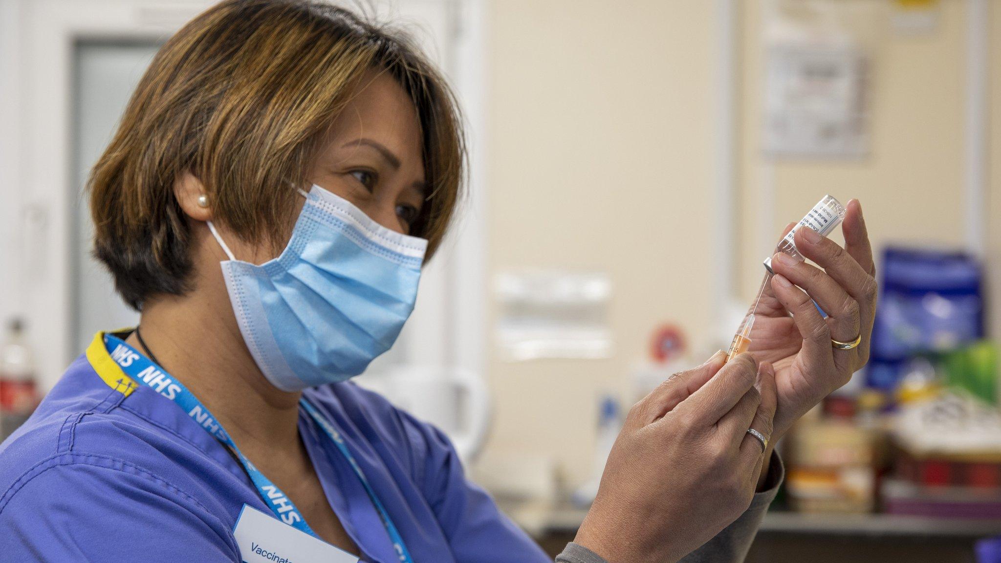 NHS worker prepares to deliver a vaccine jab