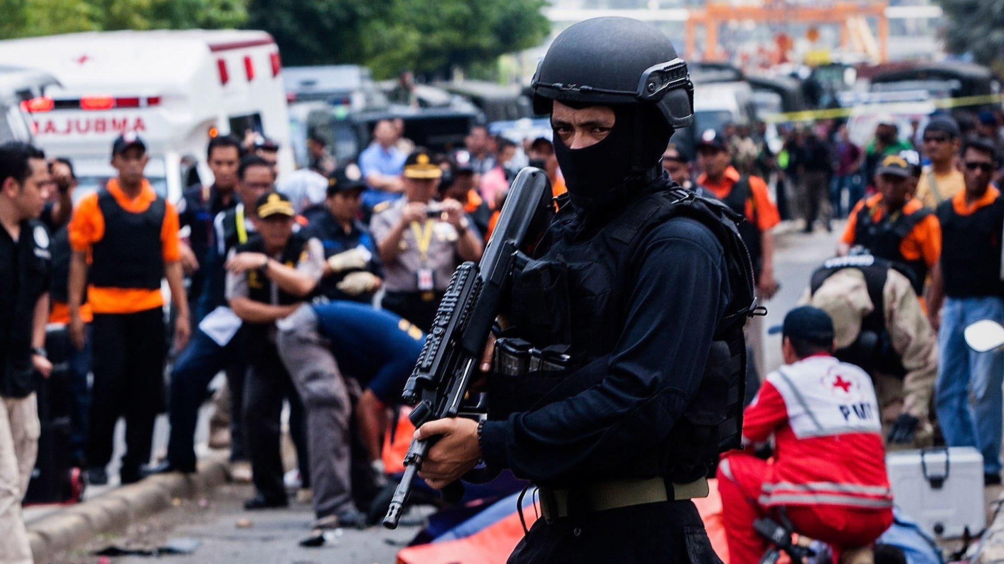 An Indonesian policeman stands guard in front of a blast site at the Indonesia capital Jakarta on January 14, 2016 in Jakarta, Indonesia