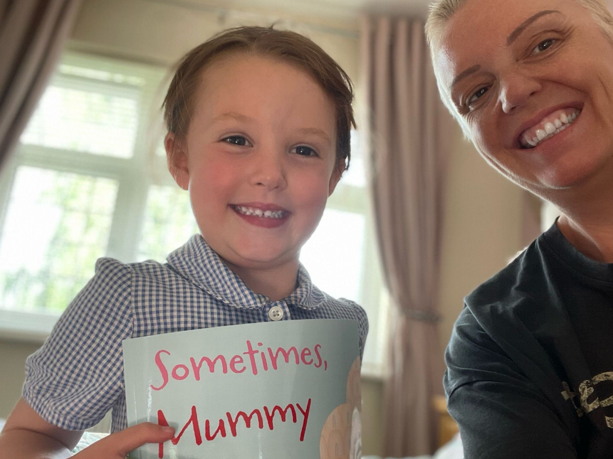 Hollie right of photo and her daughter Sydney smiling at the camera. You can see a glimpse of Hollie's book in the bottom of the frame.