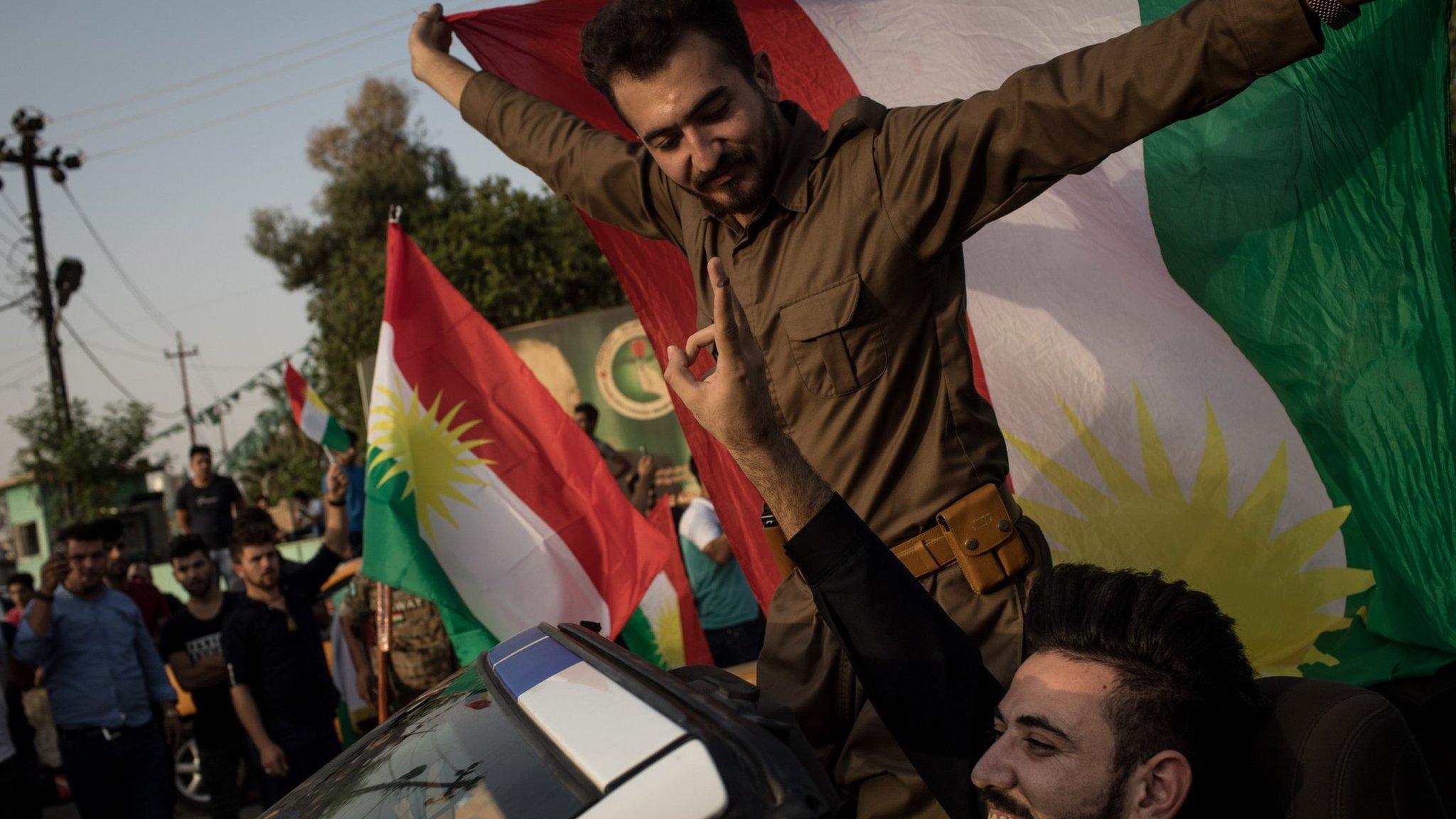 People celebrate on the streets after voting on September 25, 2017 in Kirkuk,