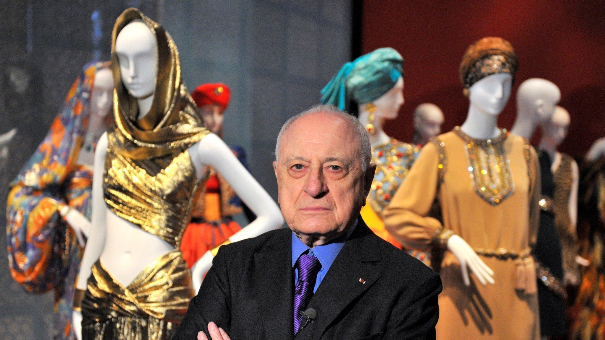 French businessman Pierre Bergé poses among creations of late French fashion designer Yves Saint Laurent at an exhibition in Paris on 8 March 2010