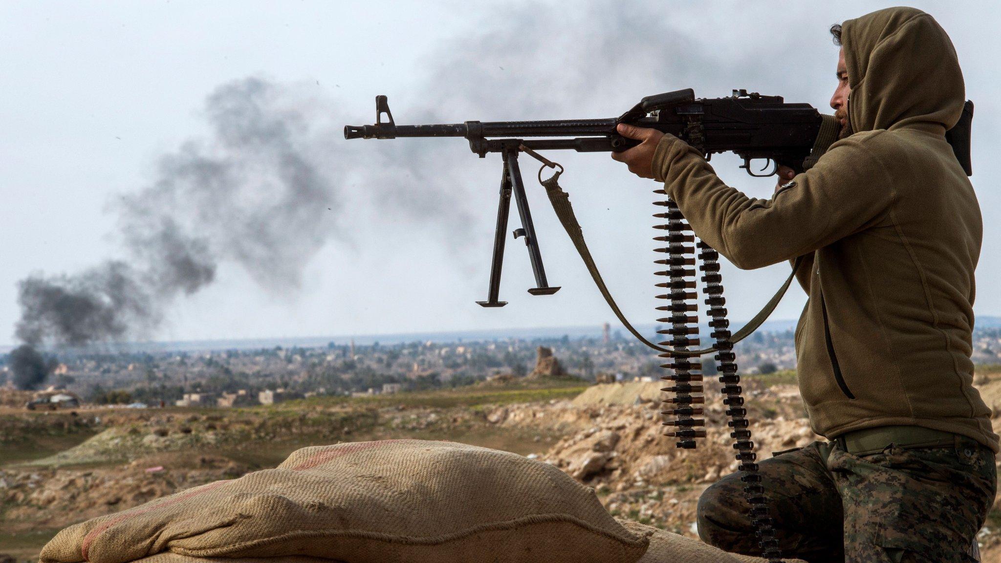 A fighter from the US-backed Syrian Democratic Forces (SDF) alliance fire at IS positions in the Baghuz area (13 February 2019)