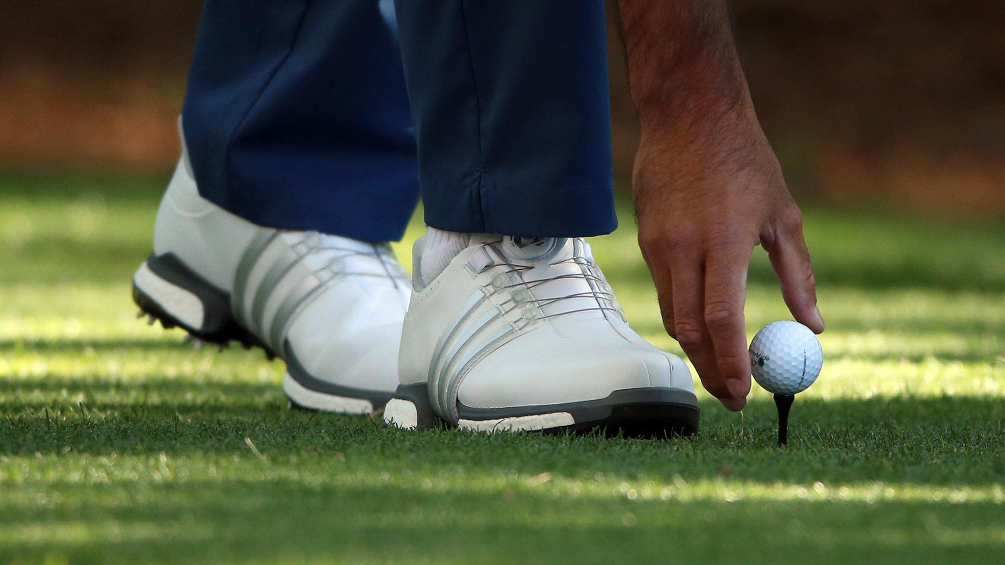 Golfer placing a ball on a tee