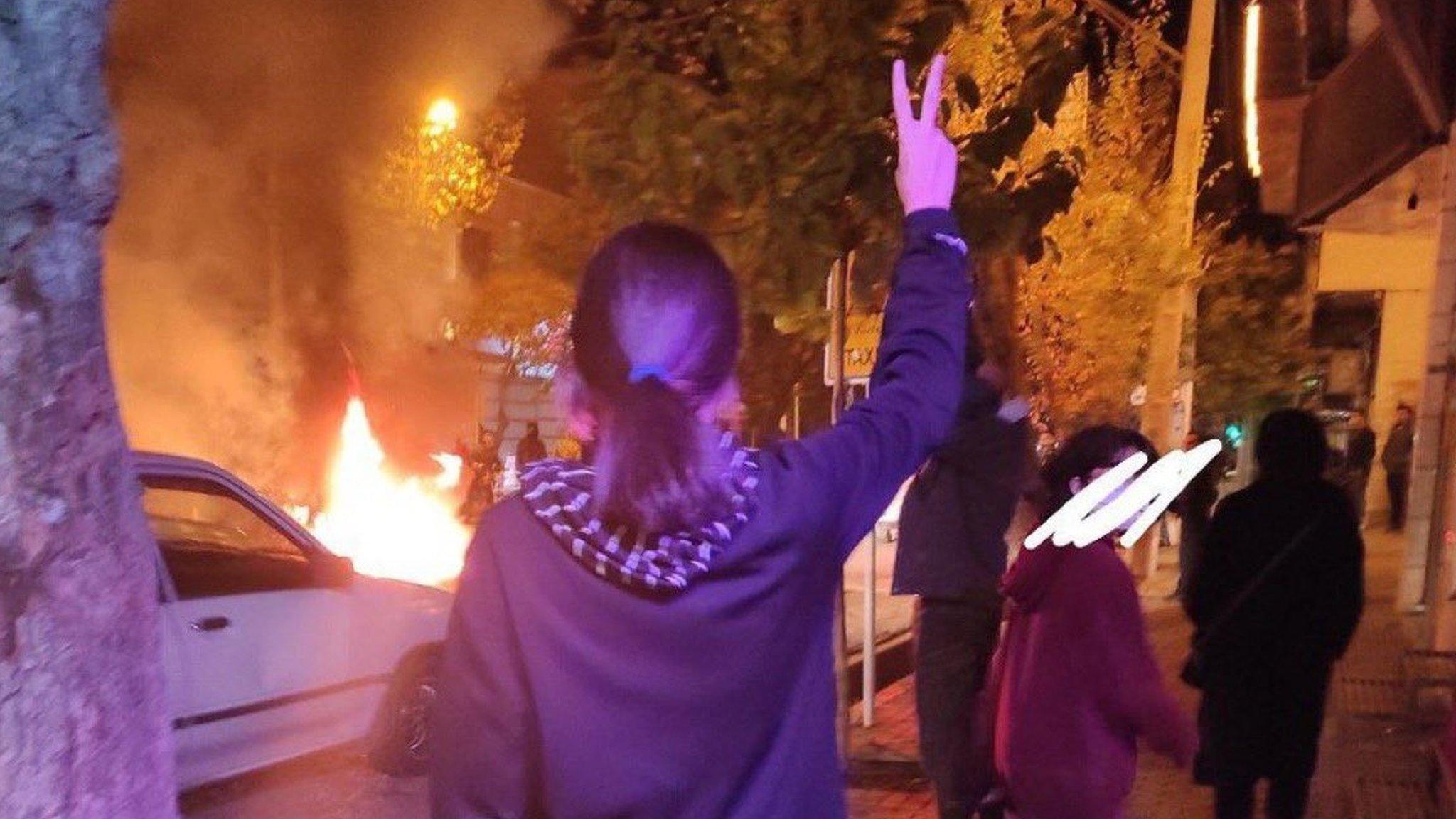 A woman without a headscarf gestures at a protest in Zarrin Shahr, Isfahan, Iran (15 November 2022)