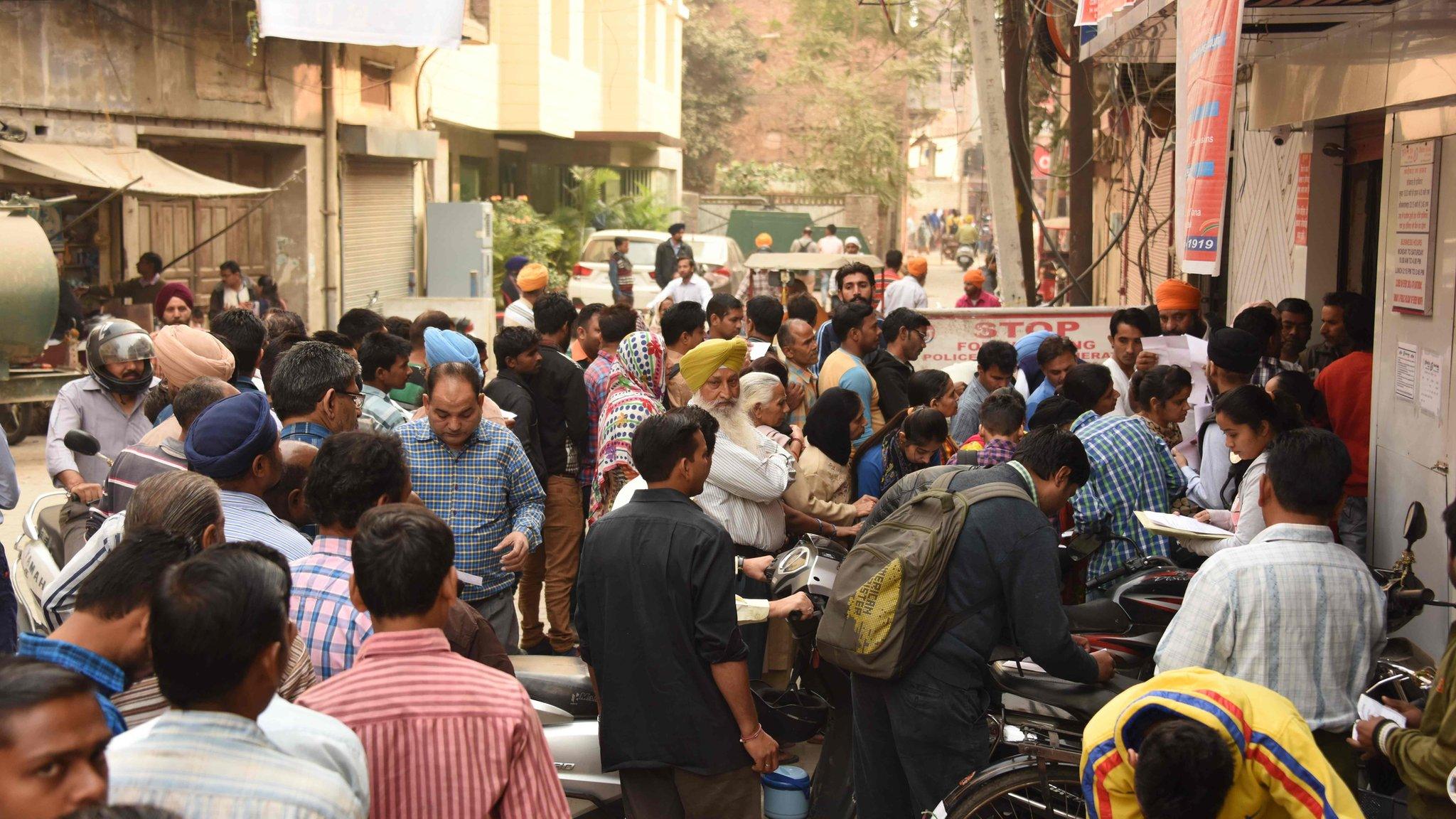 Indian people crowd outside a bank in Amristar.