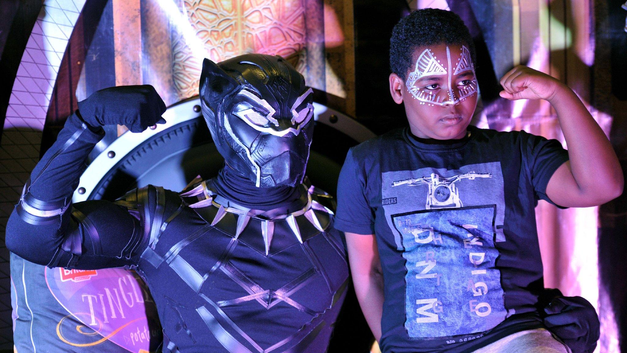 A fan poses with a cosplayer portraying a character from the 2018 US superhero film based on the Marvel Comics character, 'The Black Panther' pose in the Kenyan capital, Nairobi on February 14, 2018