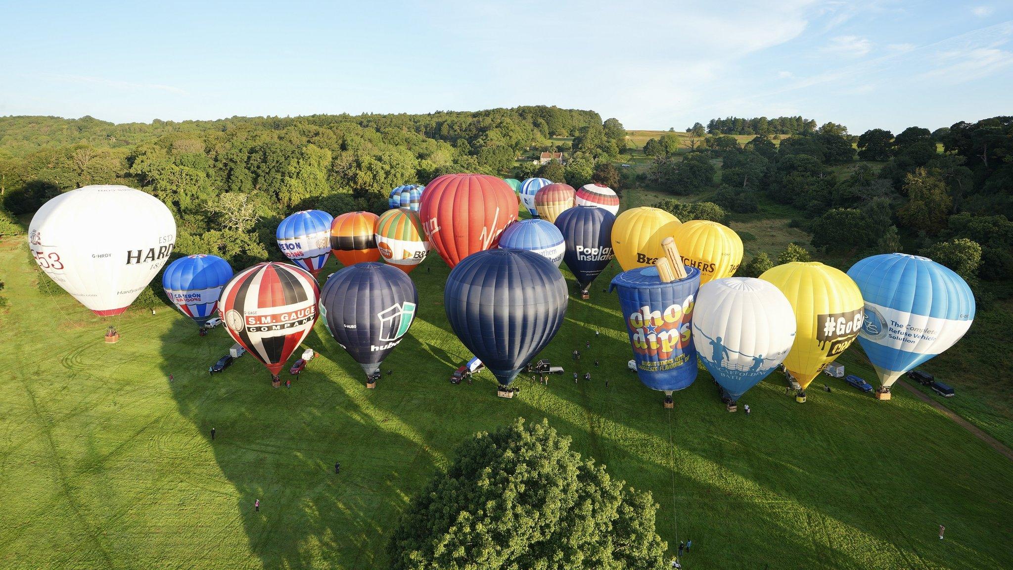 A group of colourful hot air balloons about to take off