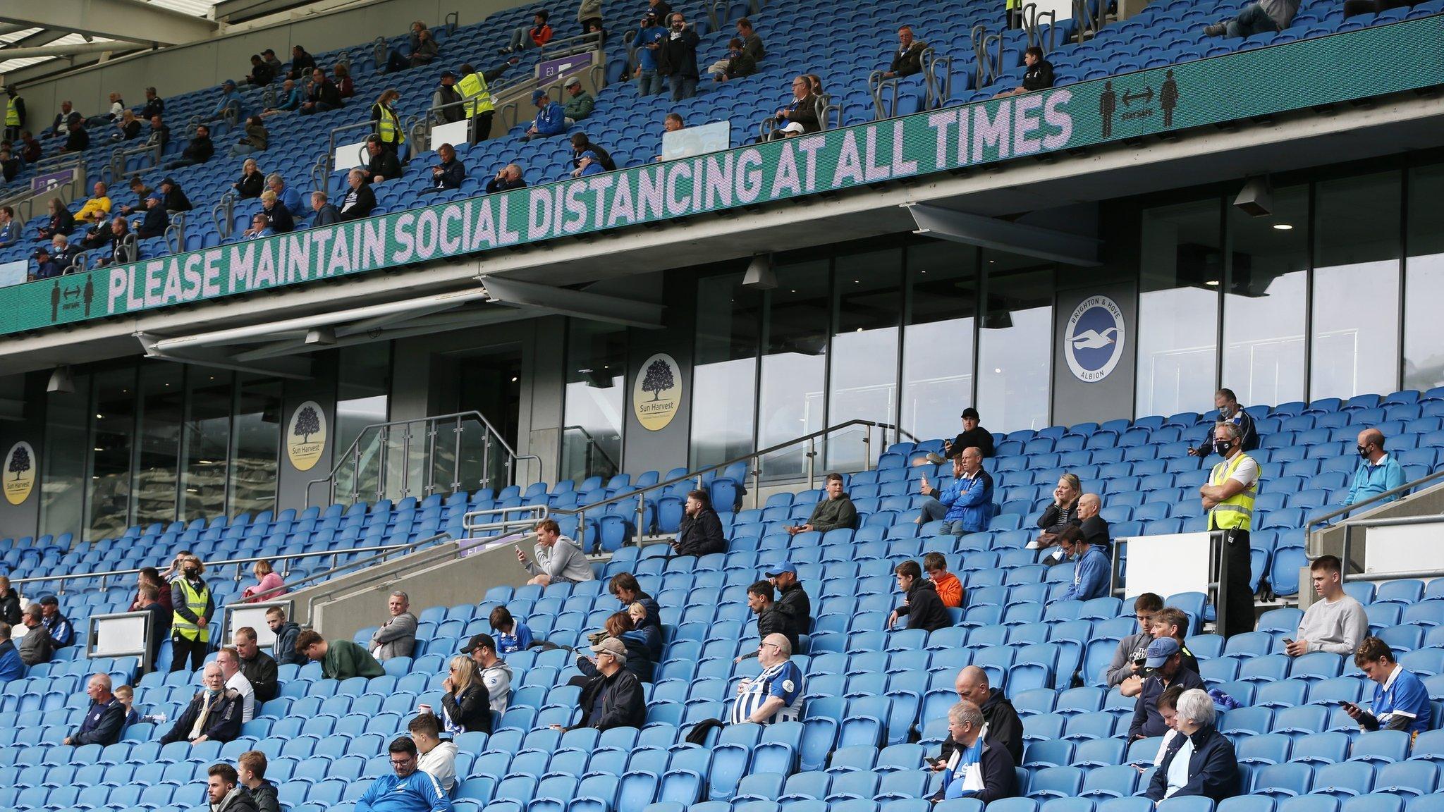 Socially-distanced fans watch a friendly between Brighton and Chelsea at the Amex Stadium